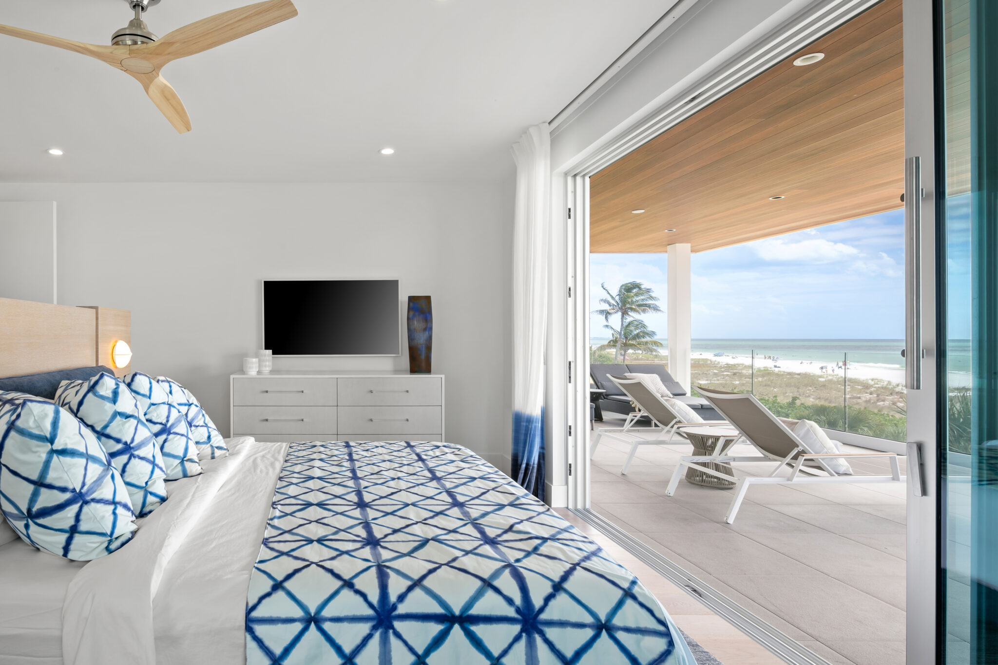 Bedroom opening to a covered balcony and the beach