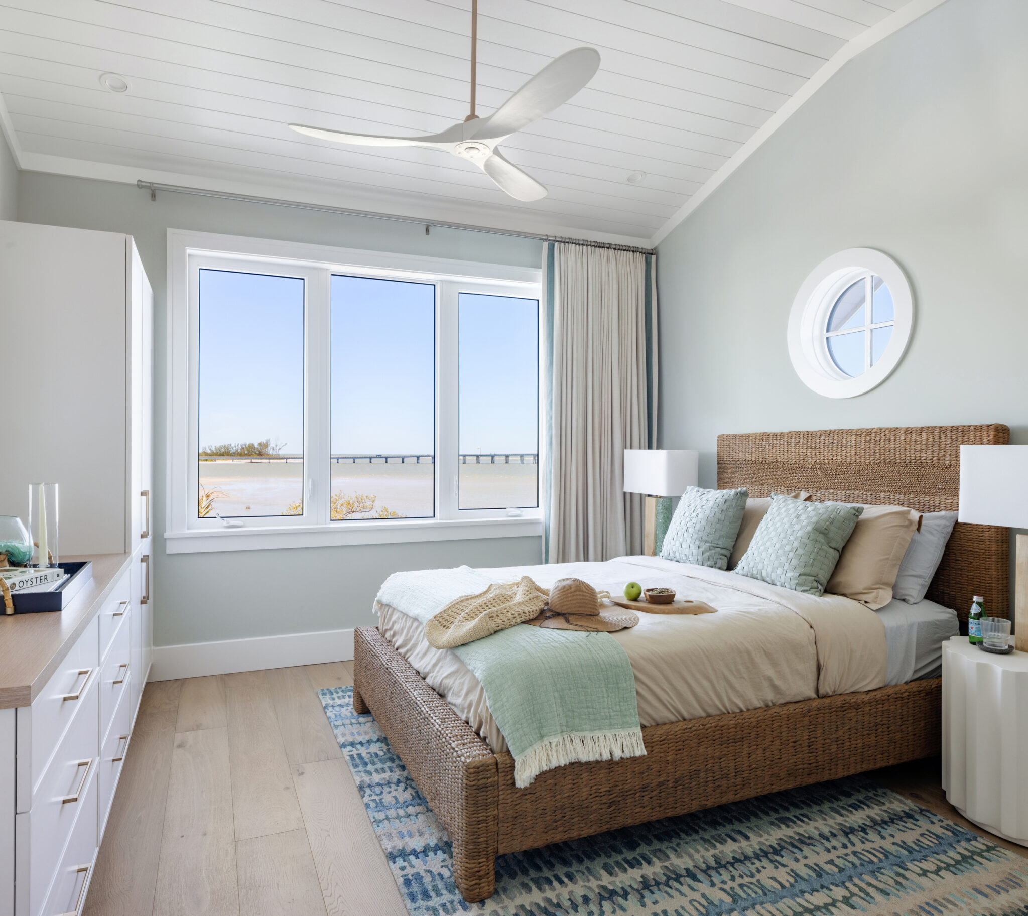 Bedroom with a round window and water view