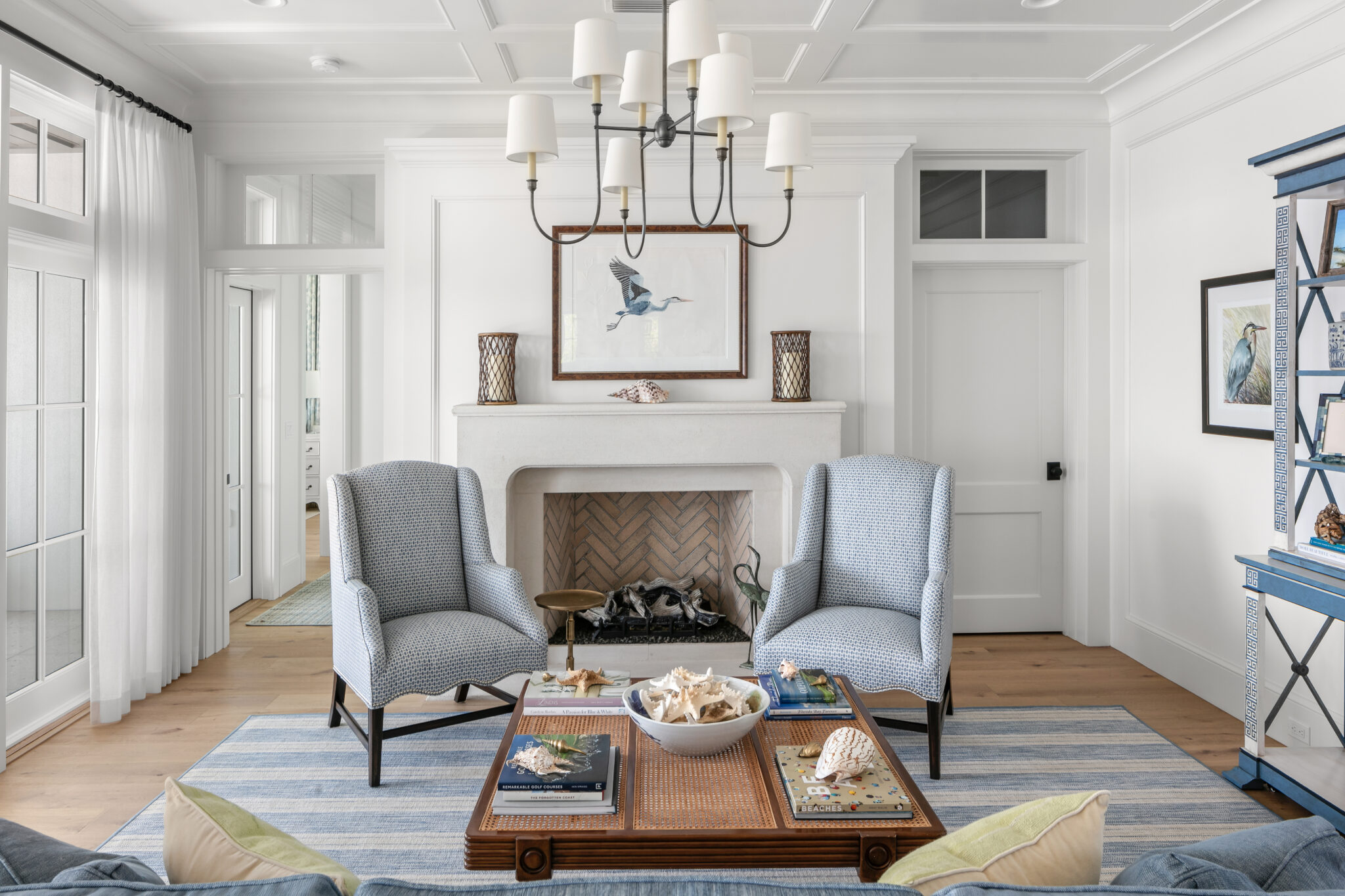 Living room with a fireplace, paneled walls and a chandelier