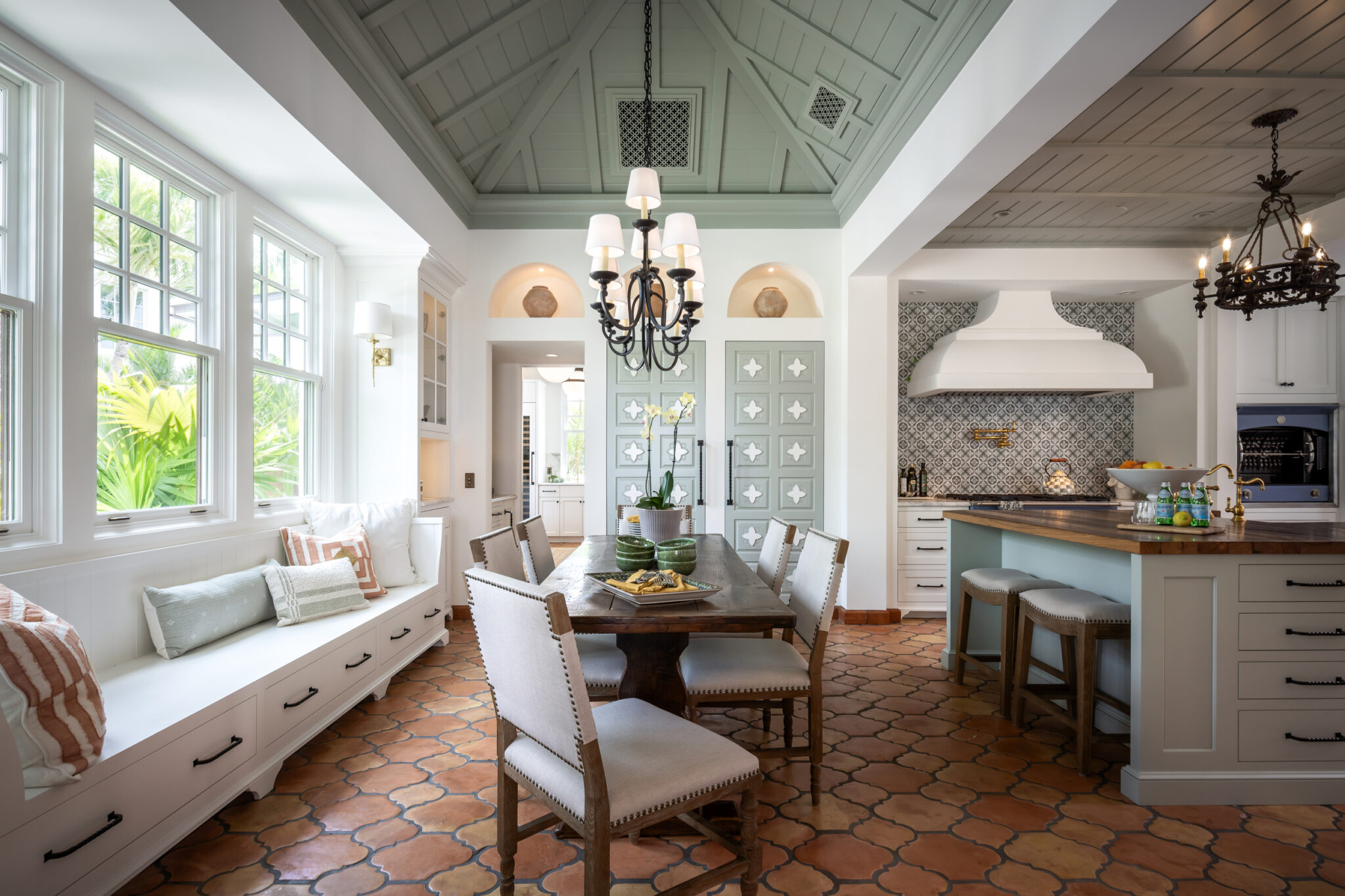 Kitchen and breakfast room with terracotta floors and wrought-iron chandeliers