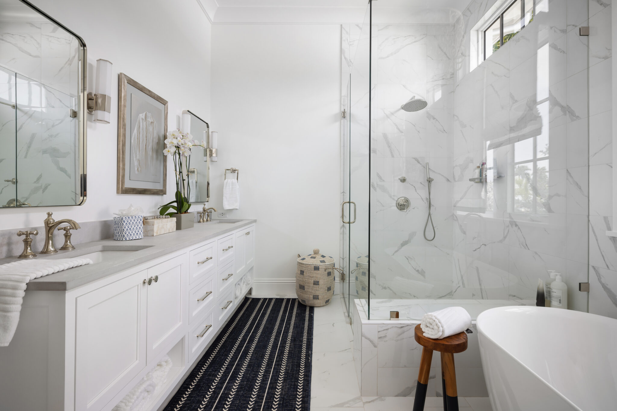 Primary bath with a glass shower, freestanding tub and double vanity
