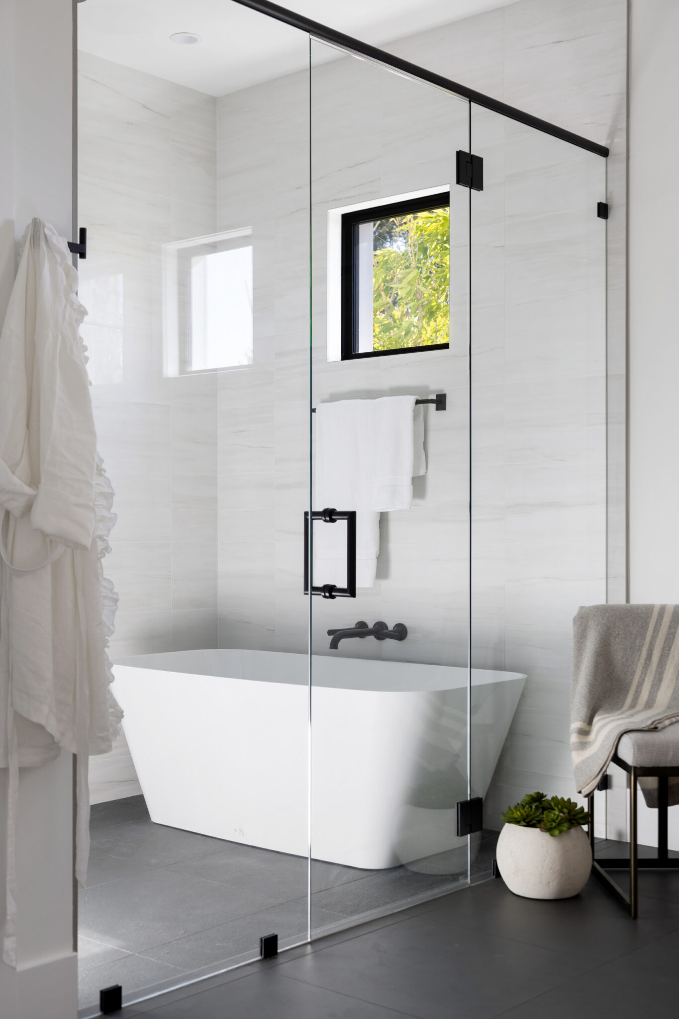 Freestanding tub inside a glass-enclosed wet room