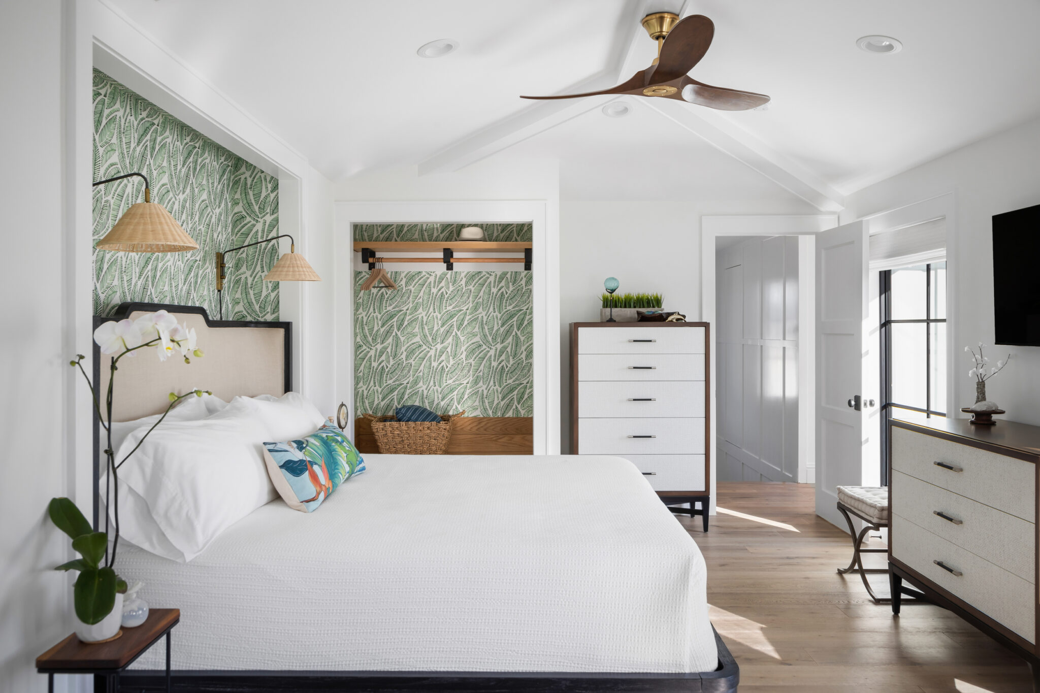 Bedroom with green botanical wallpaper and a ceiling fan