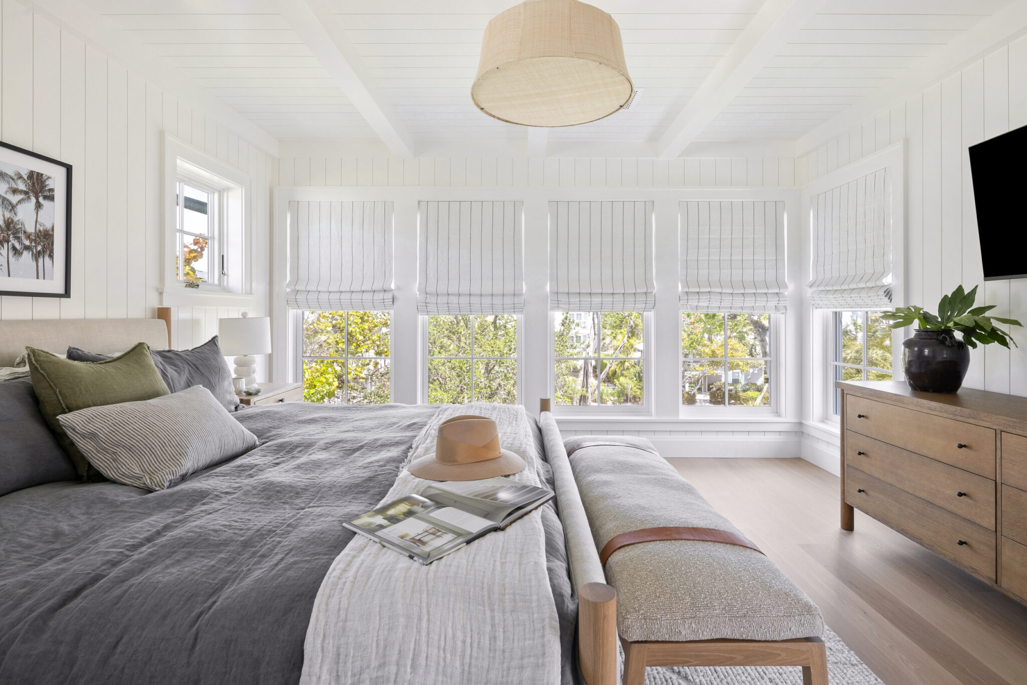 Bedroom with a wall of windows and an upholstered bench