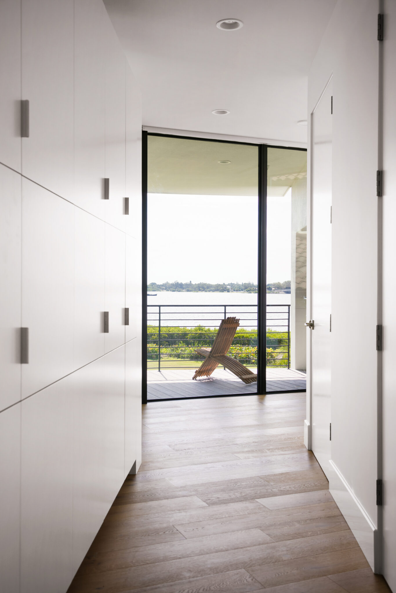 Hallway ending in a glass door to the bay
