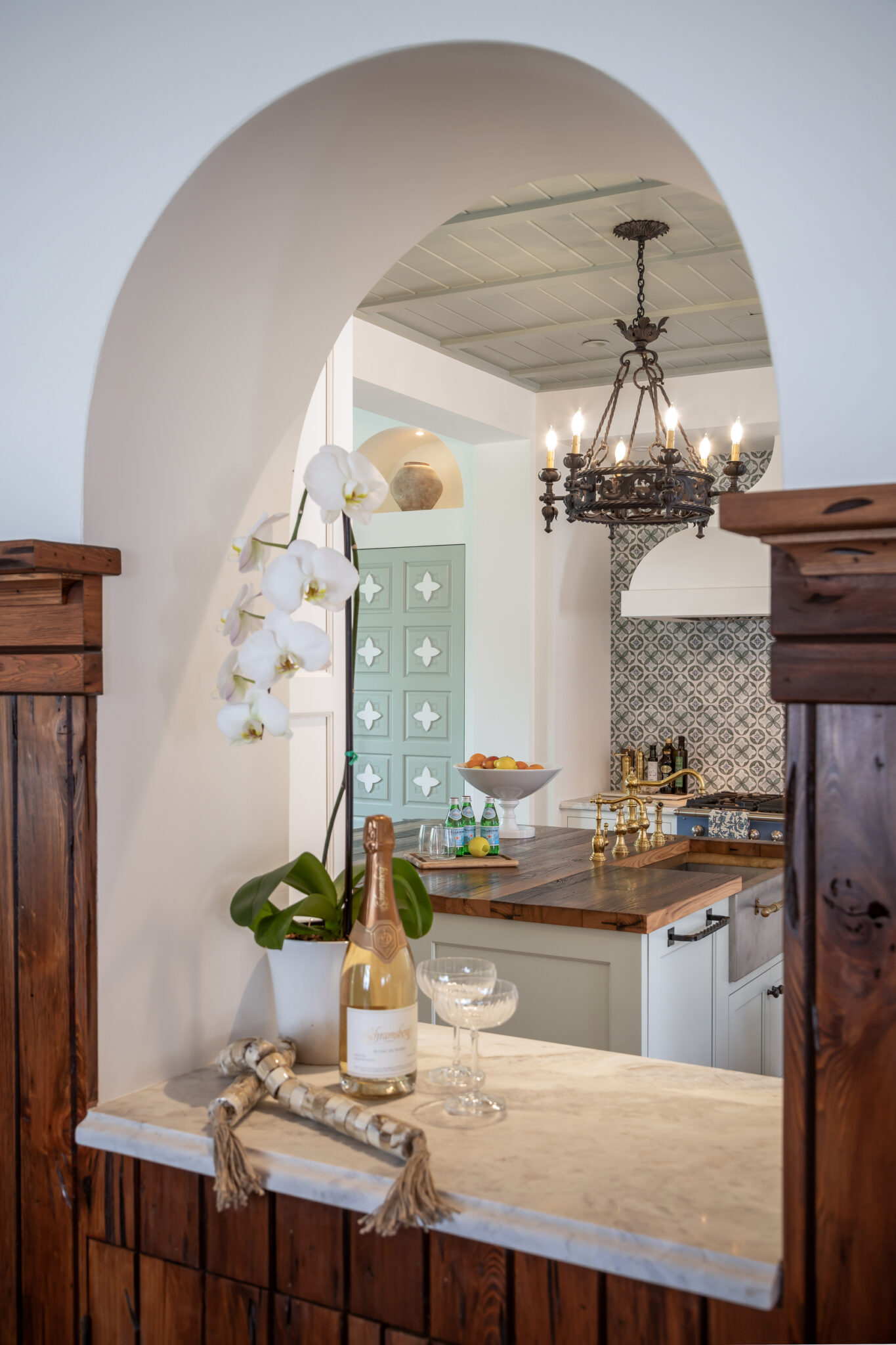 Arched pass-through with a wood counter between kitchen and dining