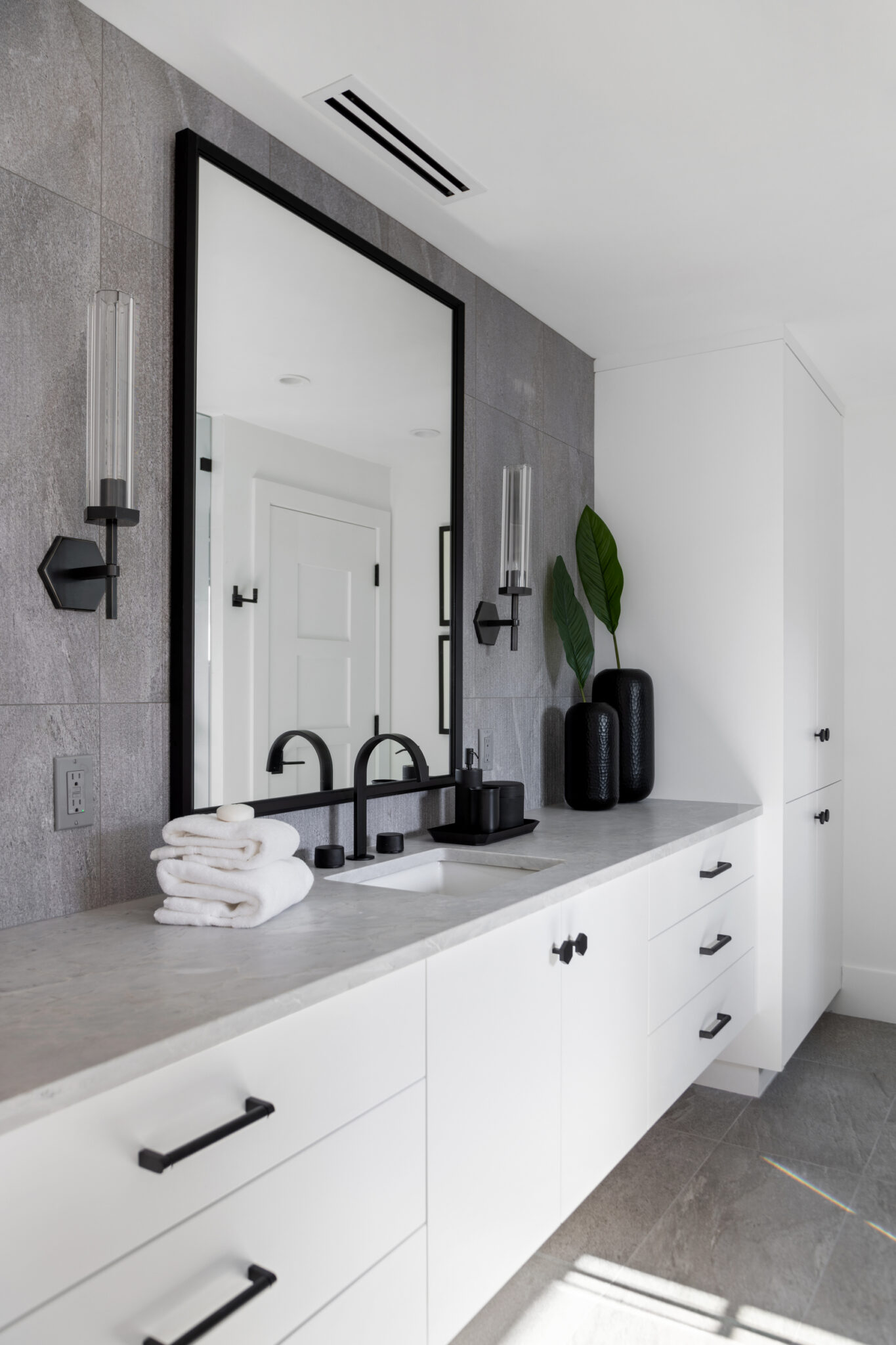 Guest bath vanity with white cabinets and black mirror