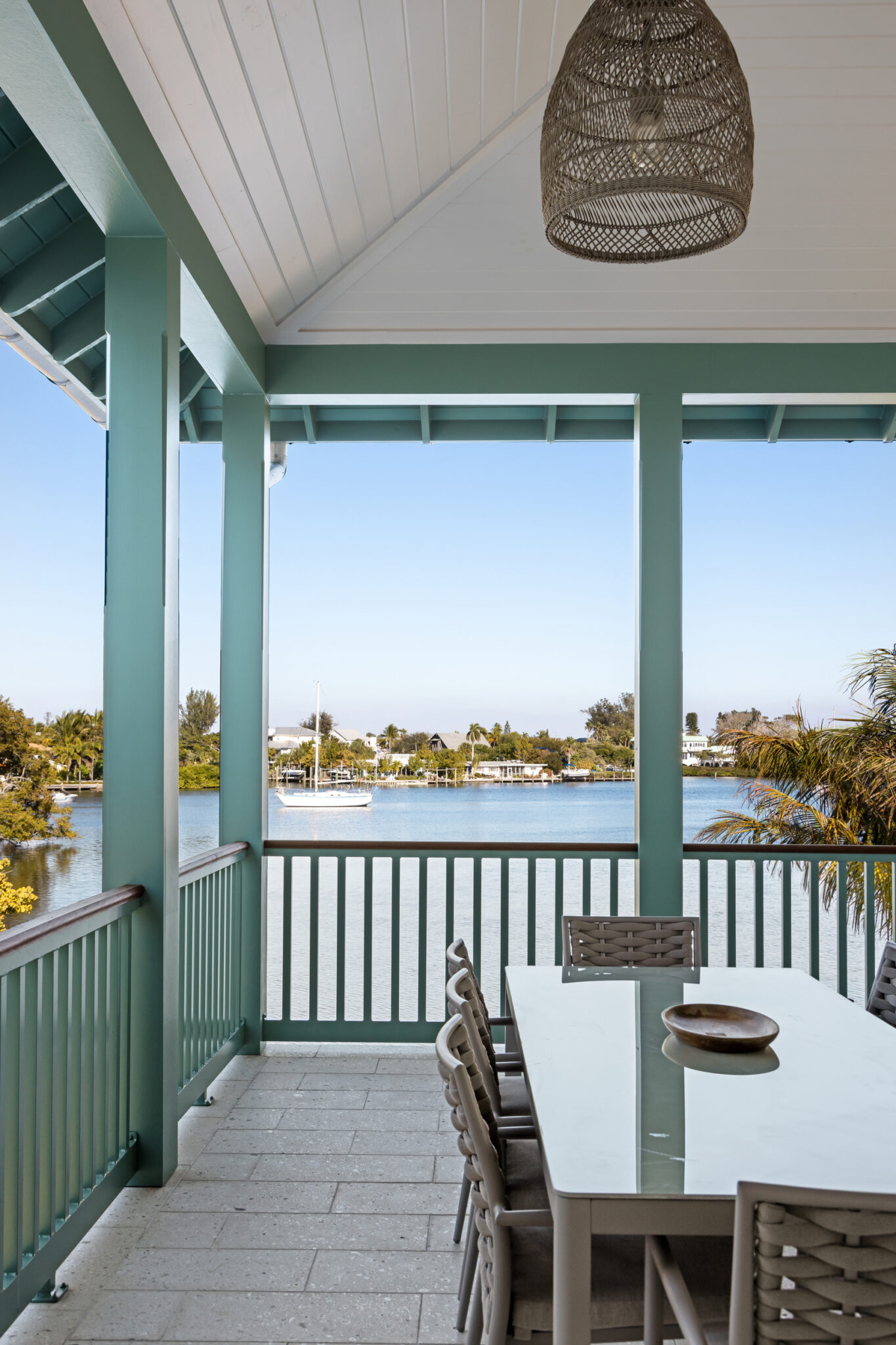 Screened porch with green trim overlooking the bay