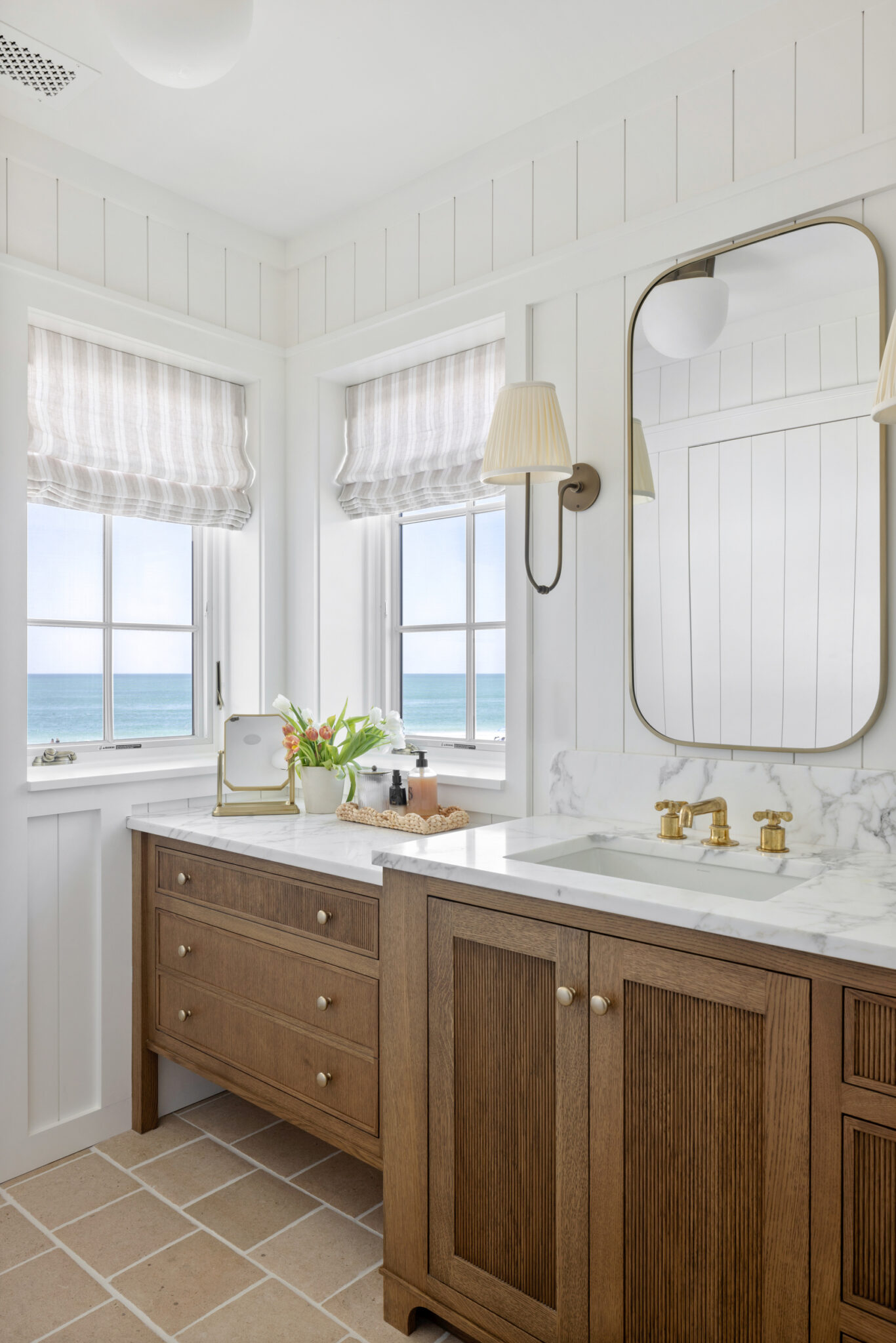 Bathroom with a wood vanity and window views of the beach