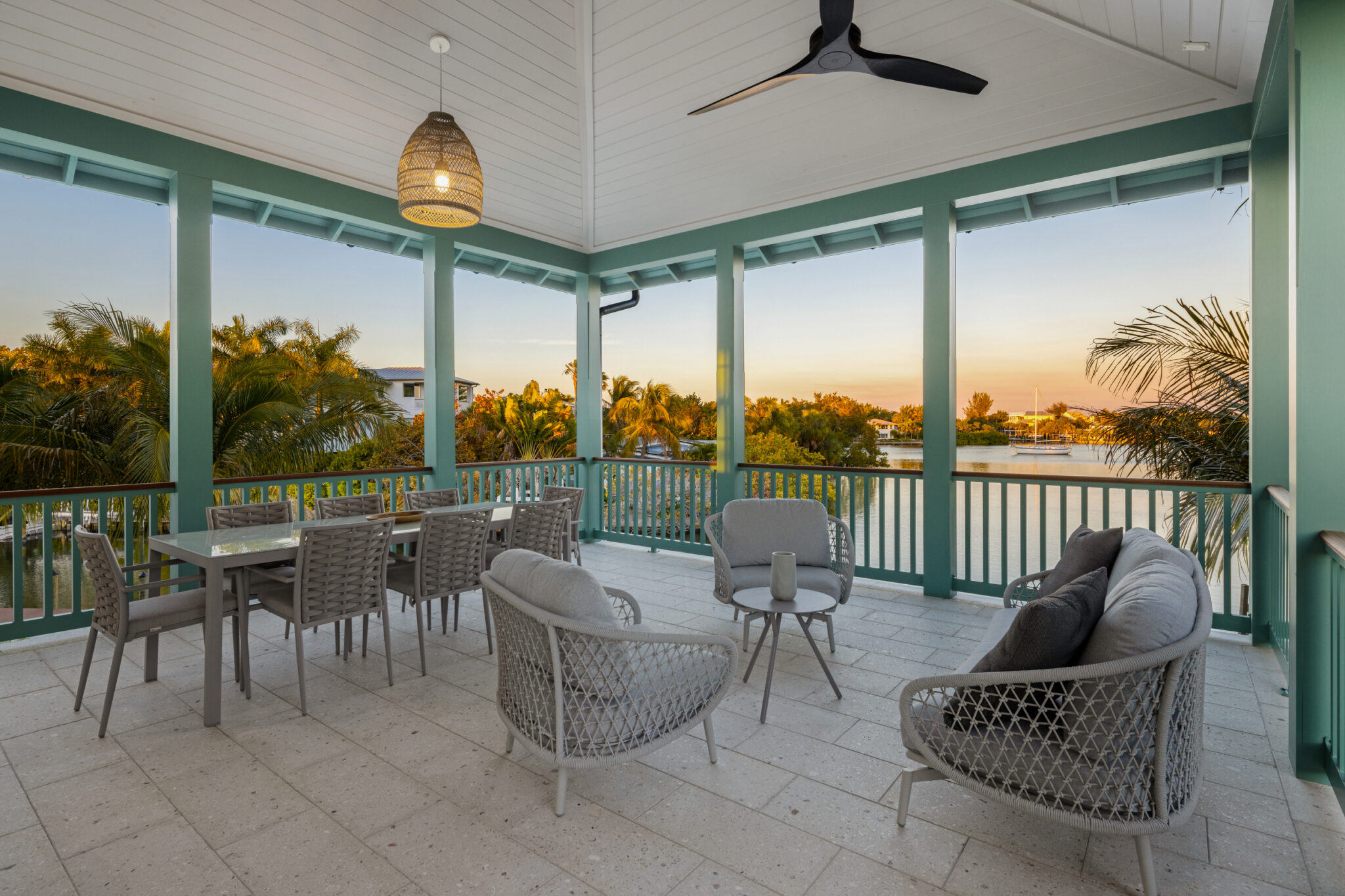 Covered porch dining and lounge chairs at sunset