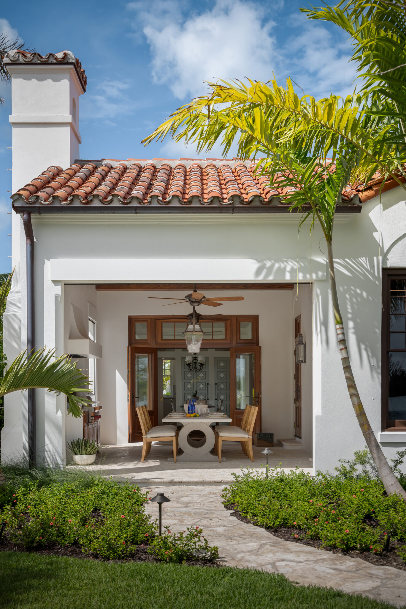 Garden courtyard leading to an open loggia with a barrel-tile roof