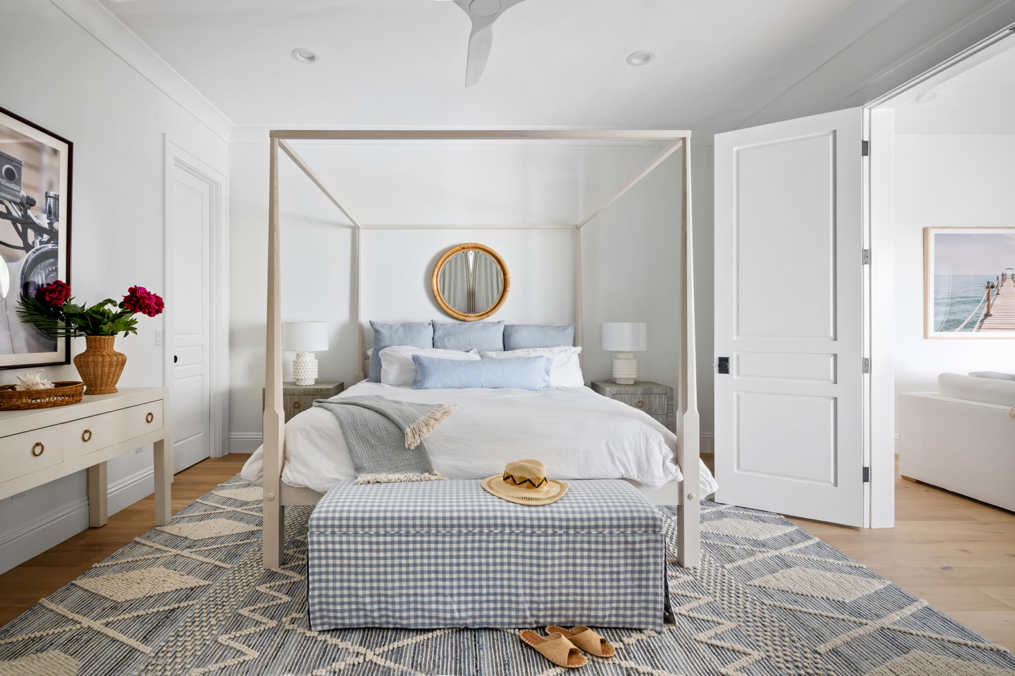 Bedroom with a white canopy bed and round mirror