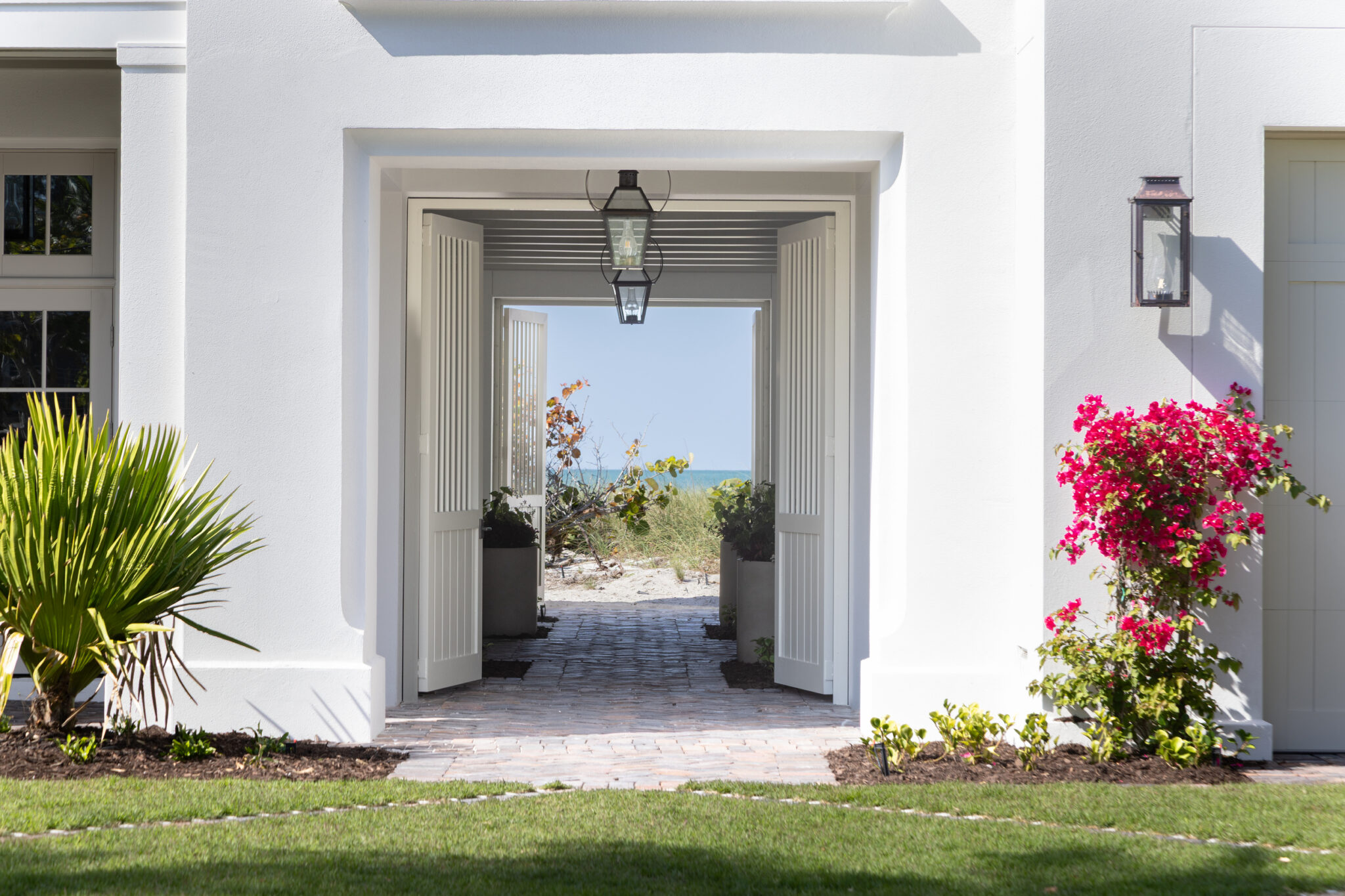 Arched breezeway opening to the beach path, framed by bougainvillea