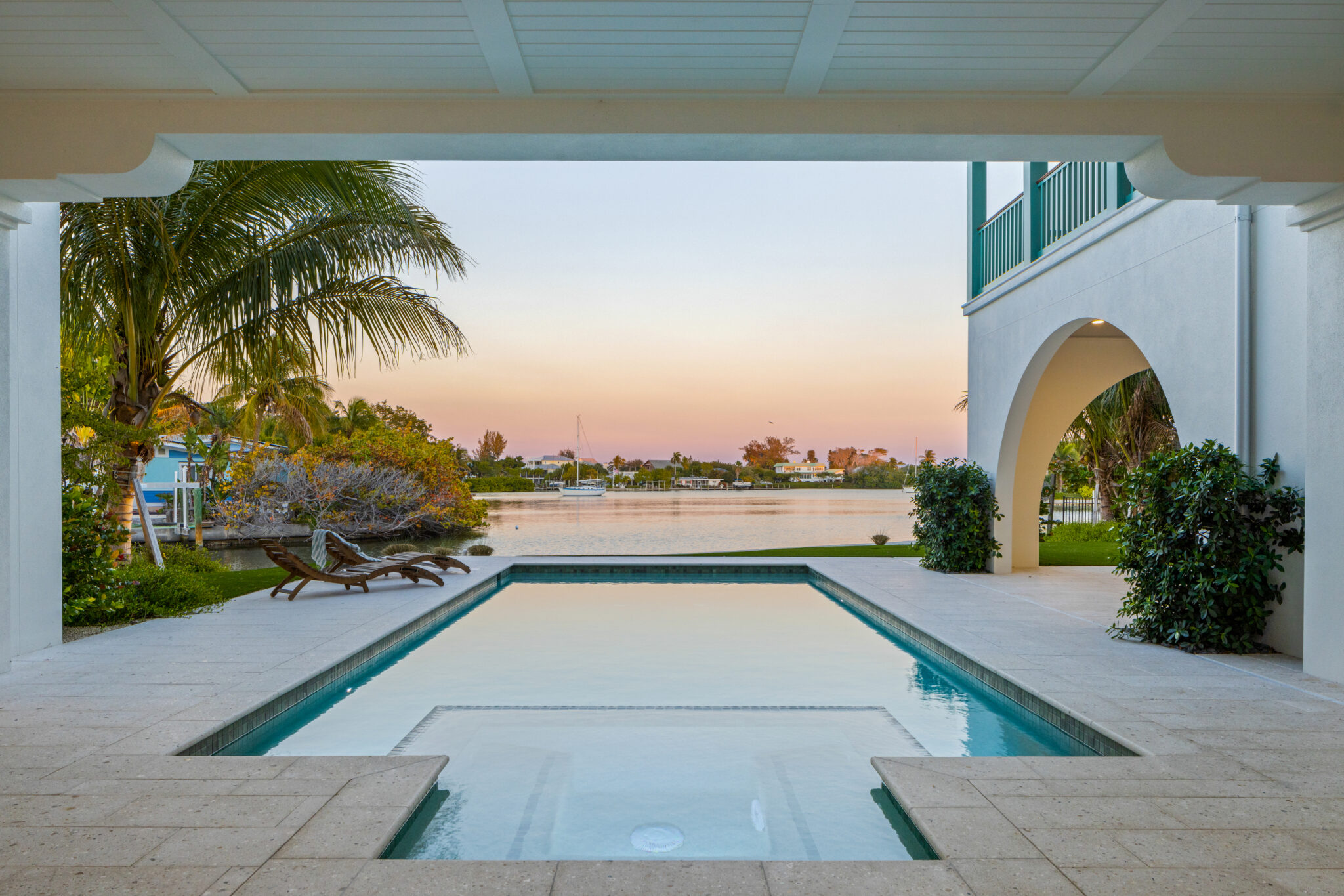 Pool framed by an arched opening looking toward the bay