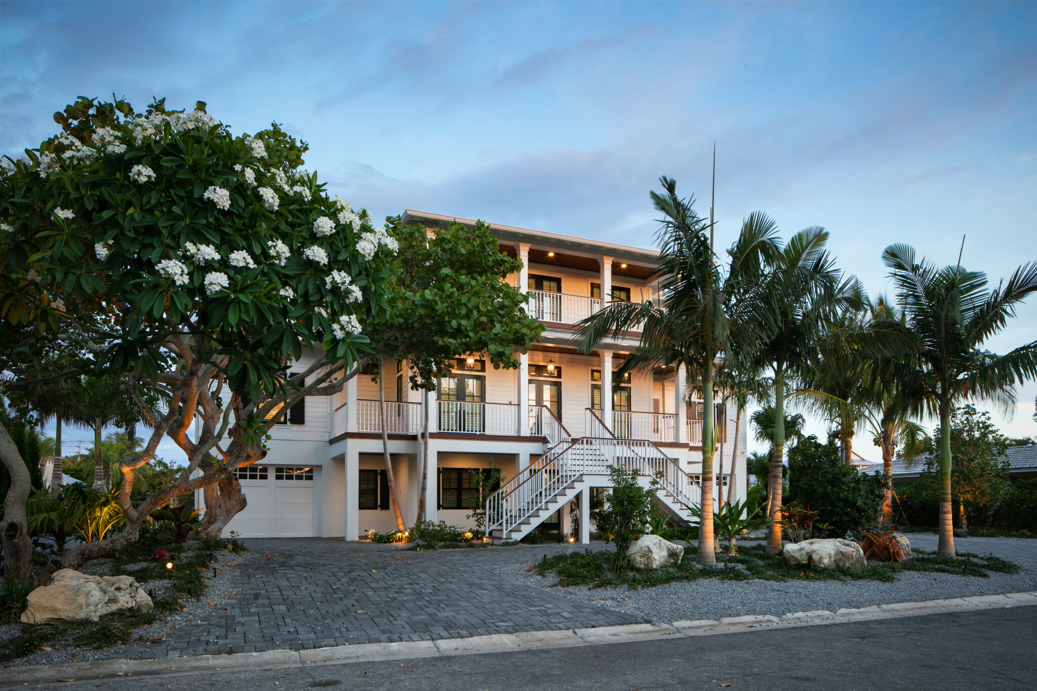 Coastal Haven, a three-level home with porches and a garage, framed by palms