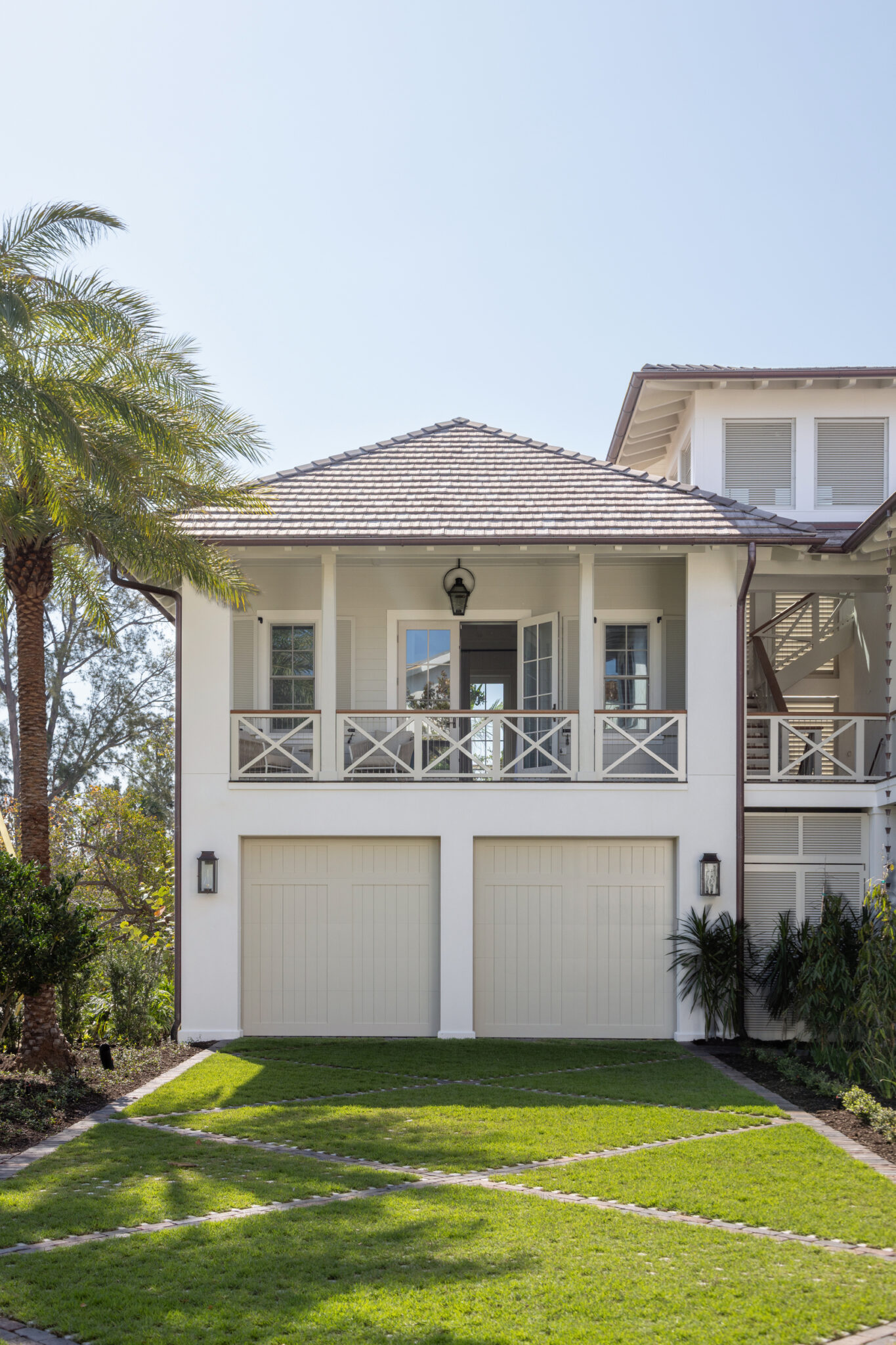 Garage wing with a balcony above and a lawn in front