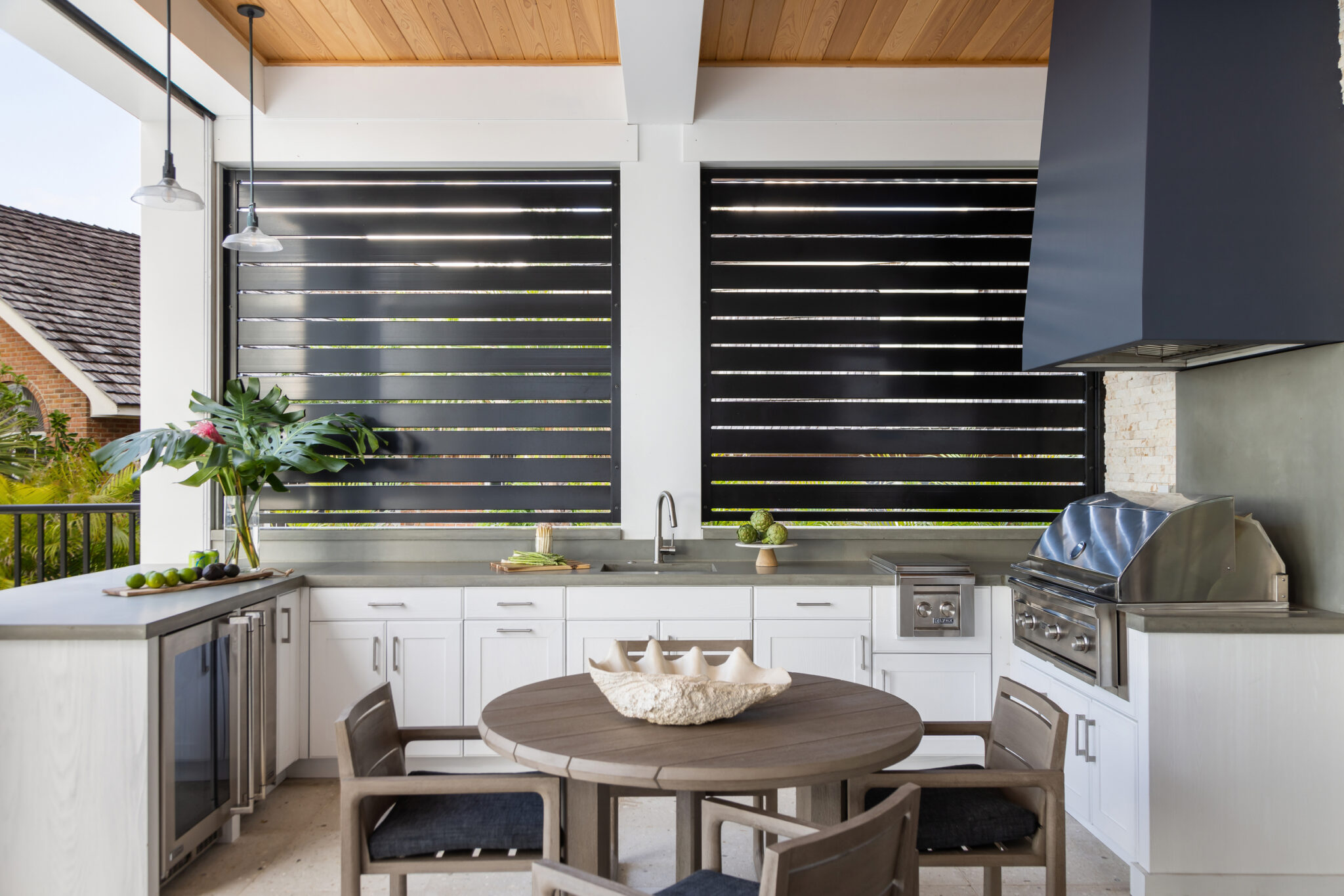 Outdoor kitchen with a black hood, grill and round table