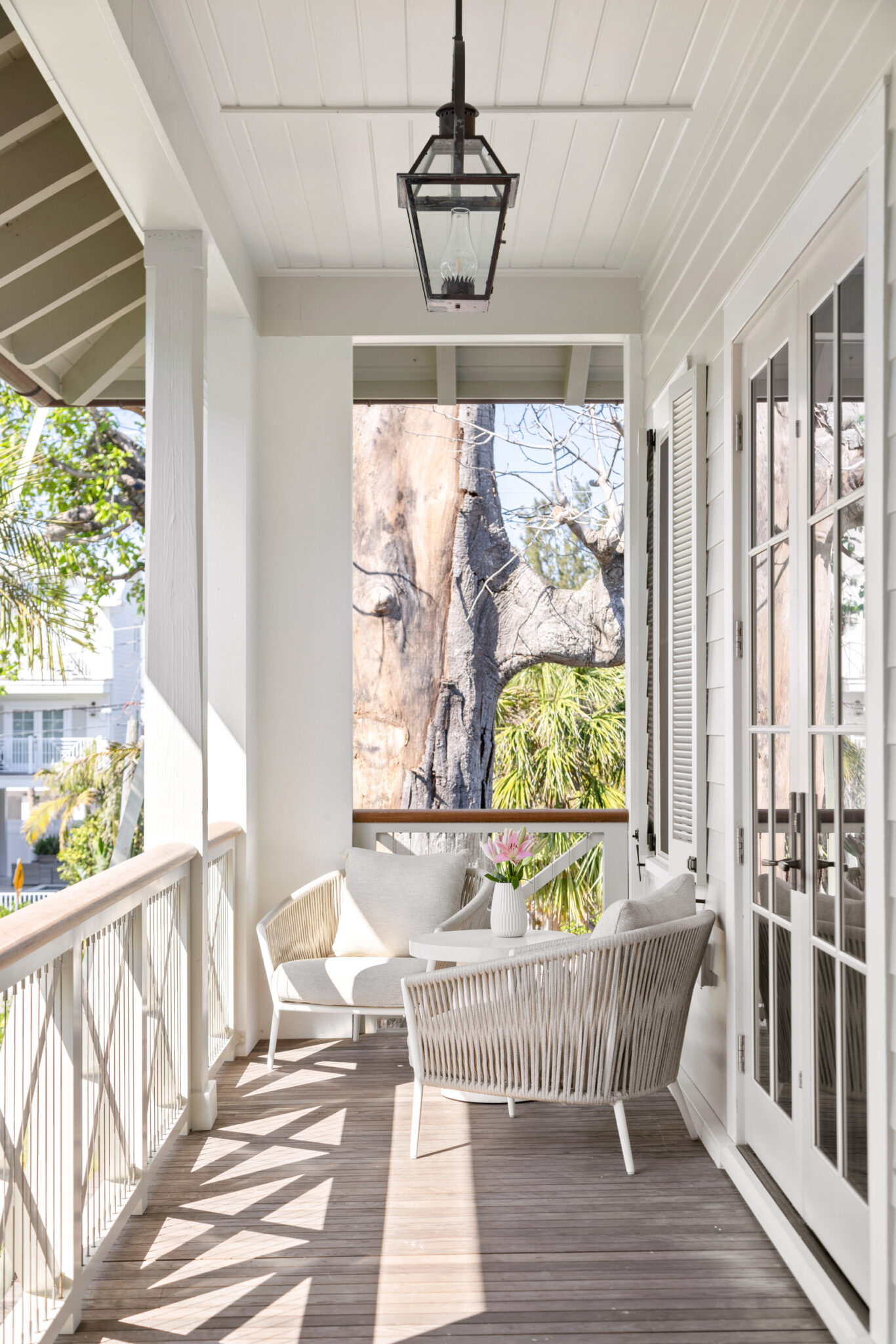 Screened porch with a lantern and a lounge chair under the trees