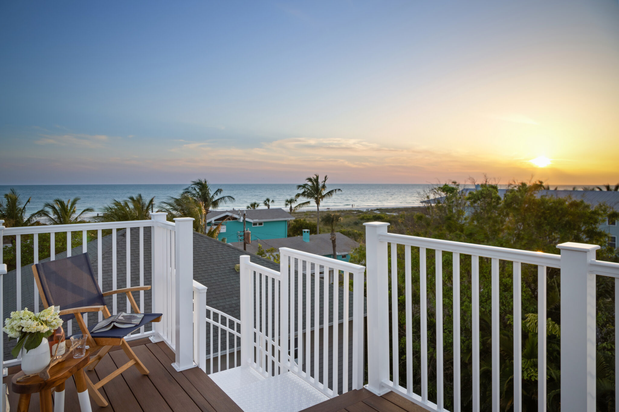 Rooftop deck at sunset with the Gulf beyond the treetops