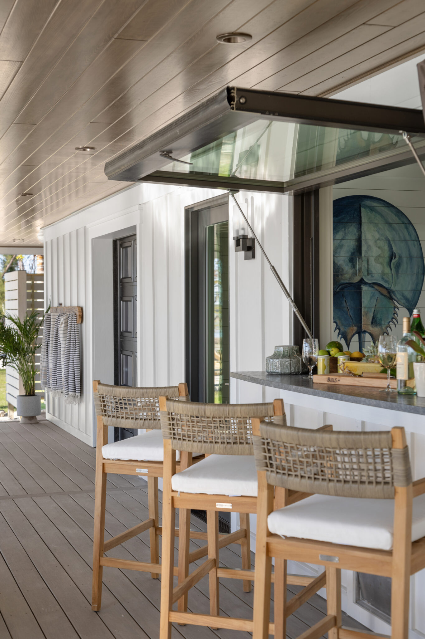 Porch bar with a pass-through window and stools