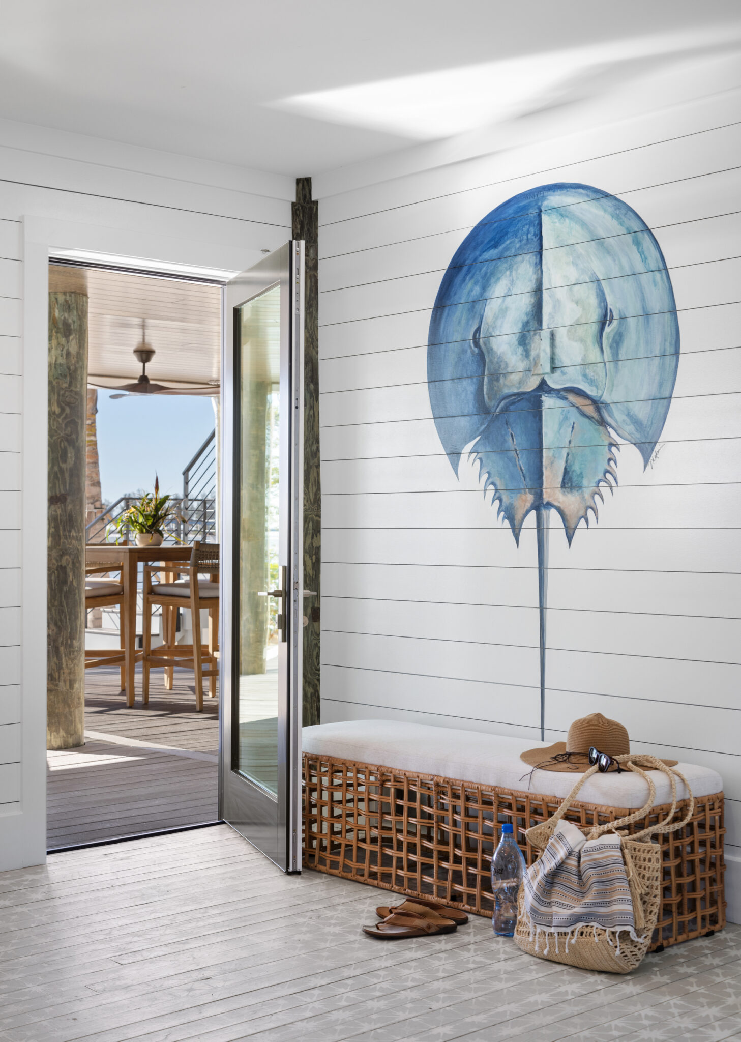 Entry with shiplap walls and a large painted horseshoe crab