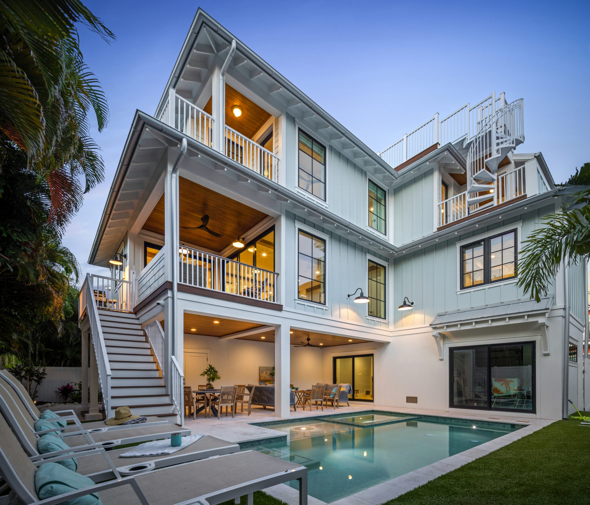 Rear of Beachwalker with layered porches, stair and lit pool