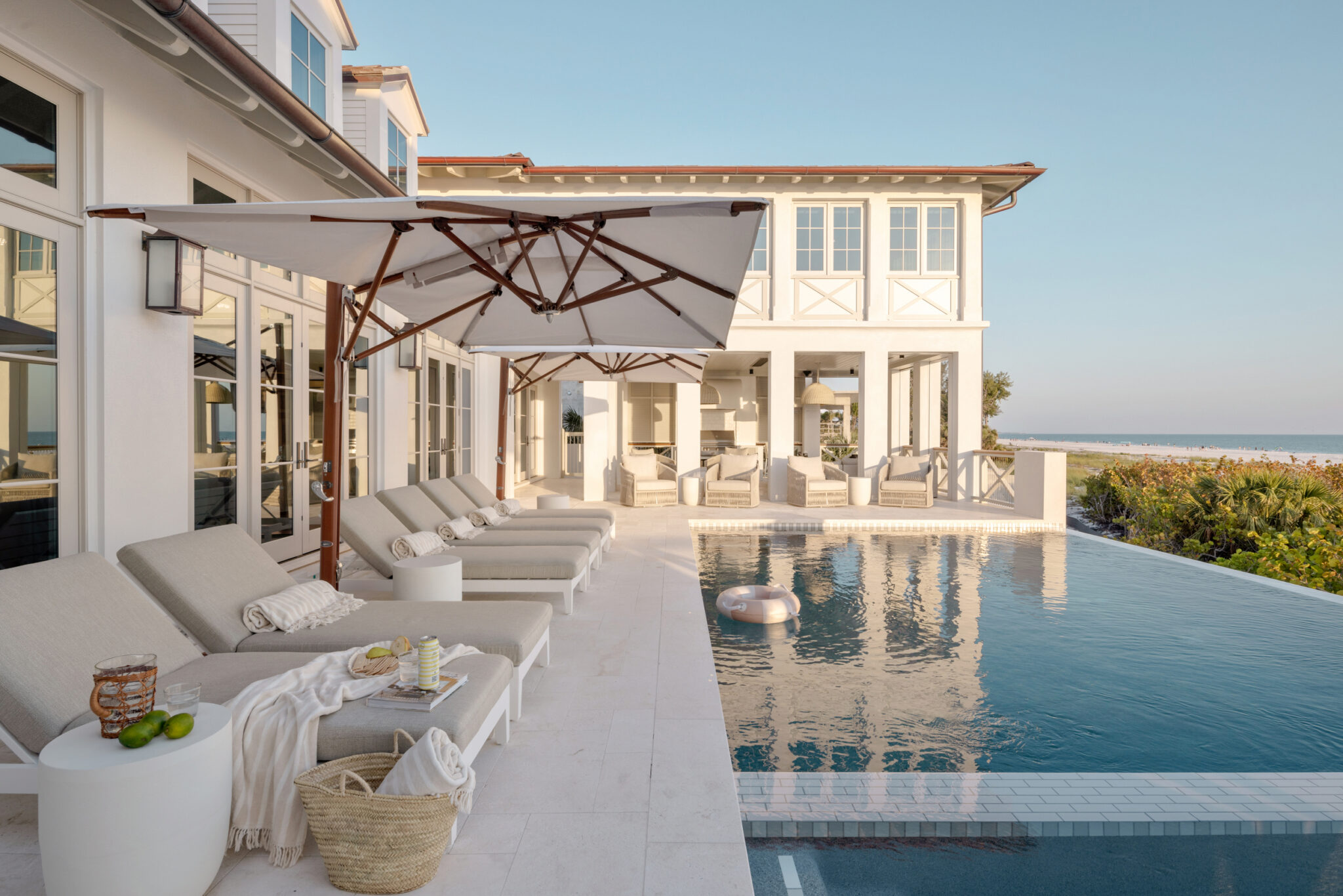 Infinity-edge pool and lounge chairs beside the house, facing the Gulf