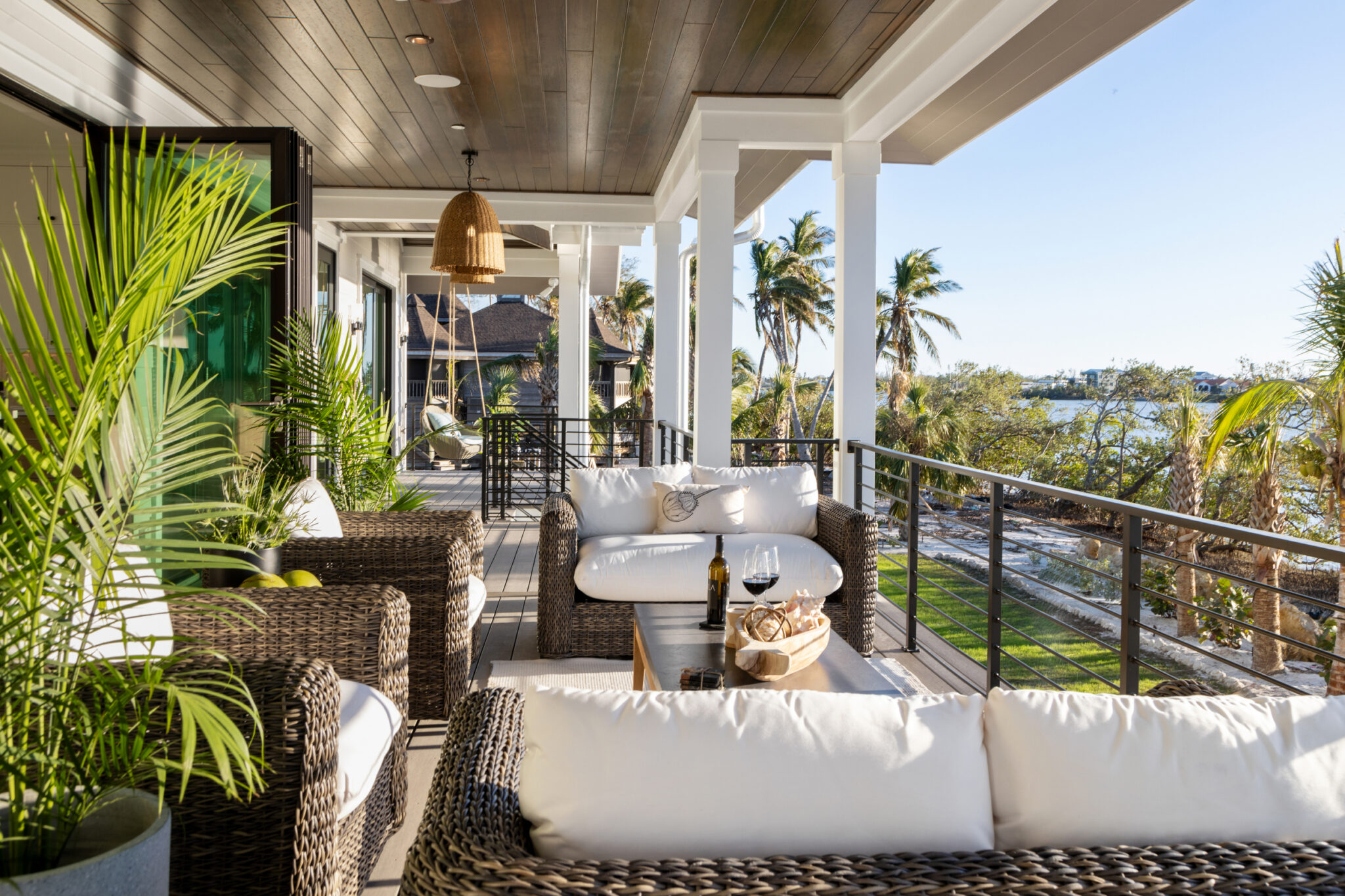Wraparound porch with woven sofas and bay views