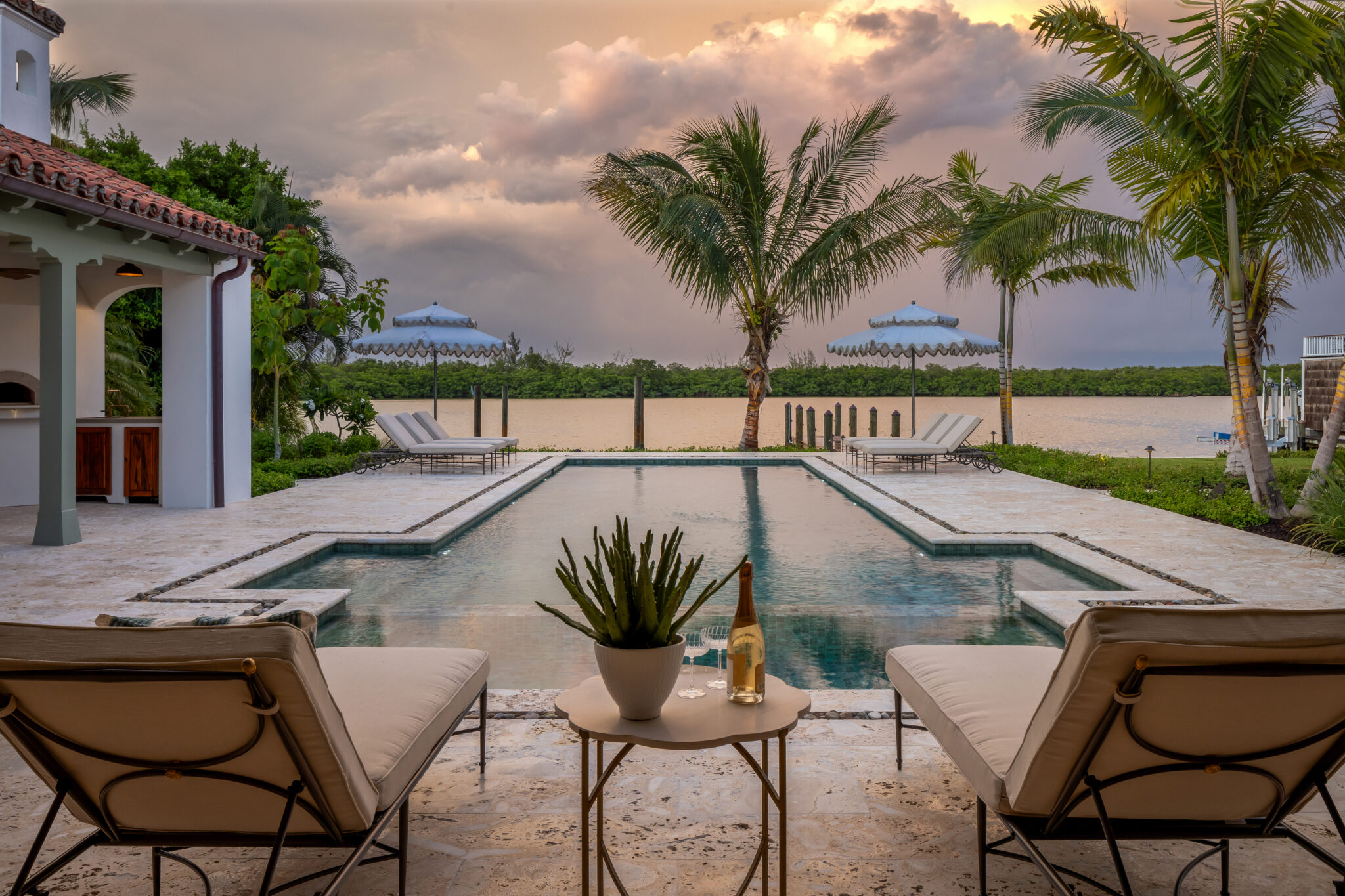 Pool terrace and lounge chairs at sunset, looking out to the bay