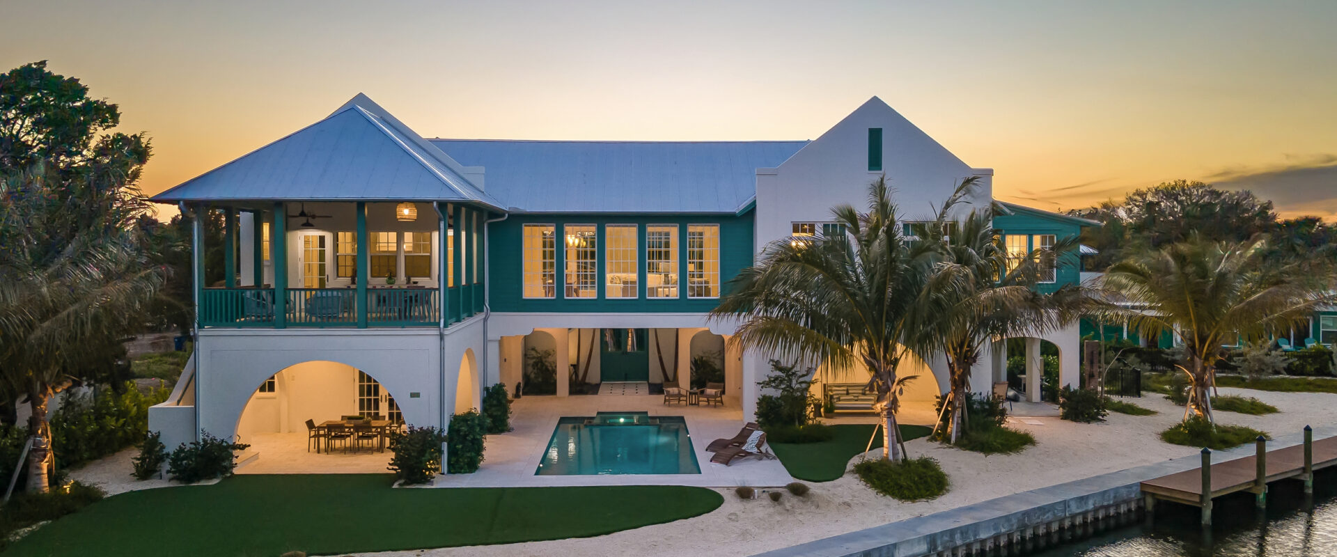 Bimini Bay House from the water at dusk, with seawall and pool