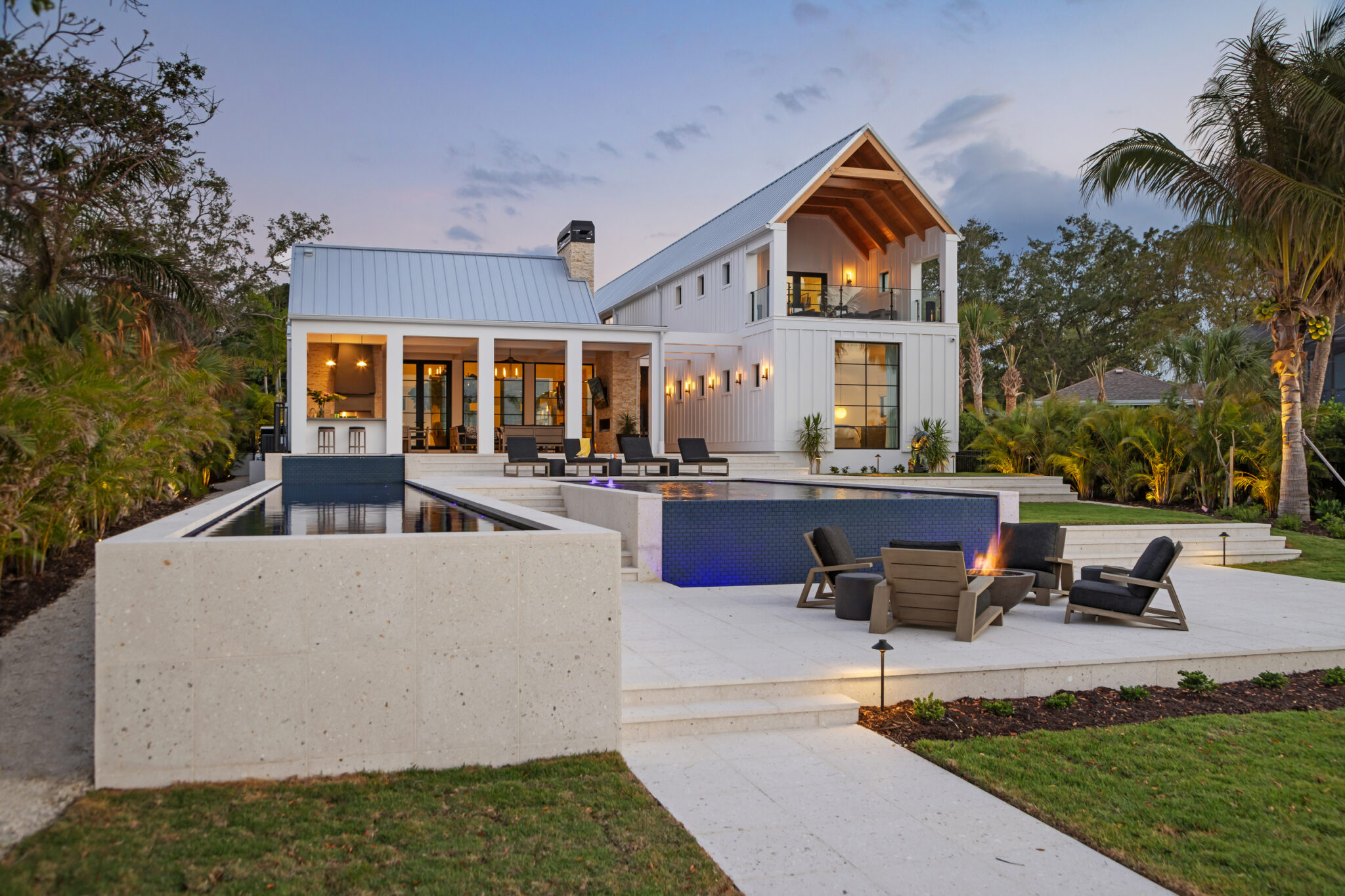 Rear of Modern River House with a raised pool terrace and fire pit