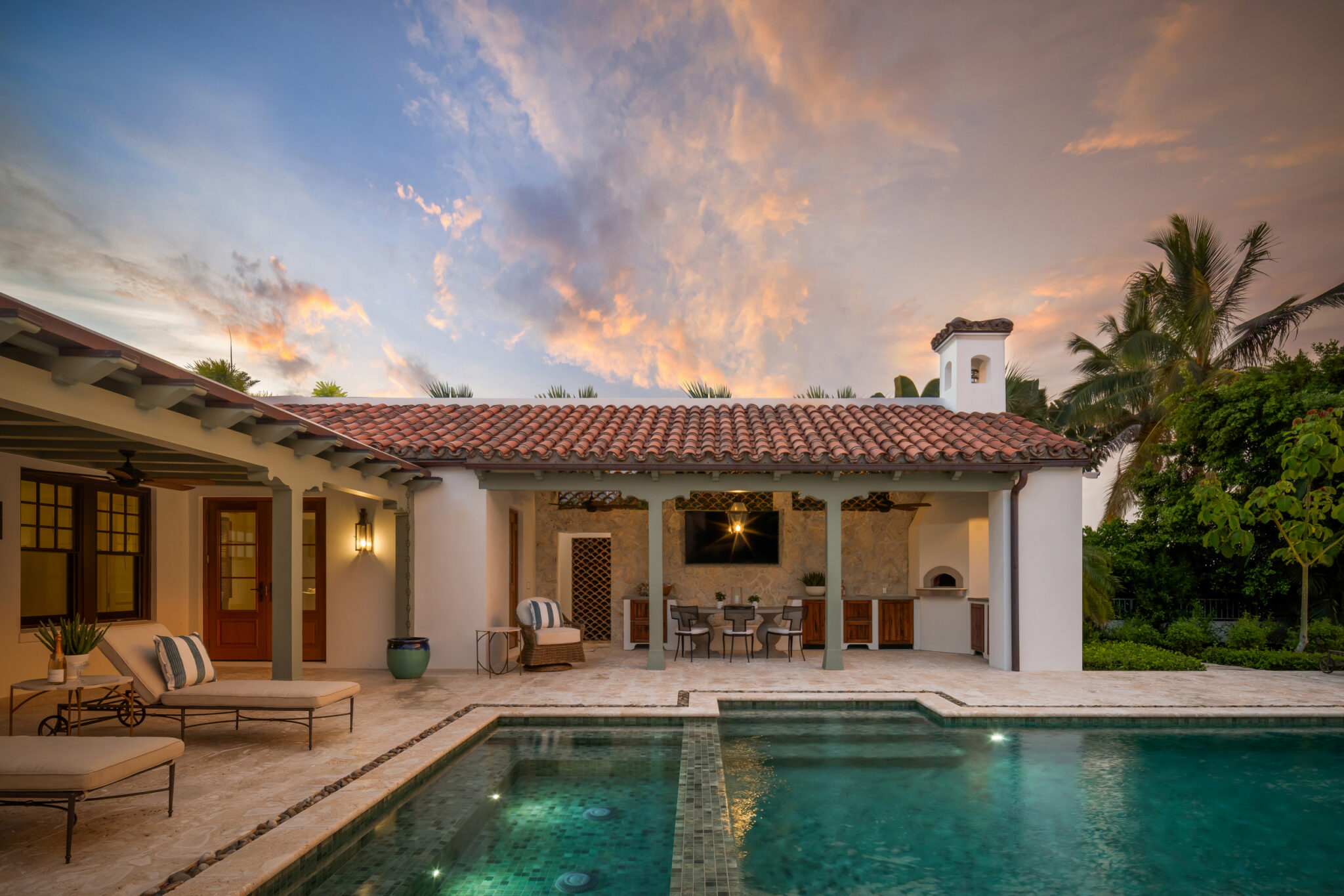 Pool and covered loggia under a sunset sky