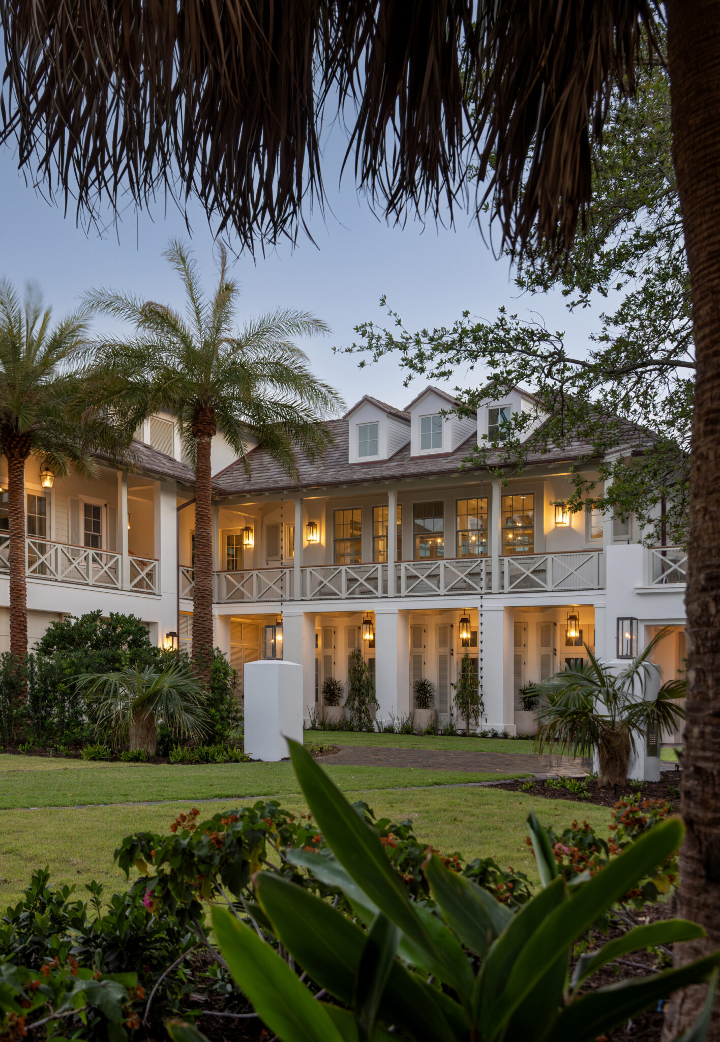 Porches and palms of the North Shore Residence lit at dusk