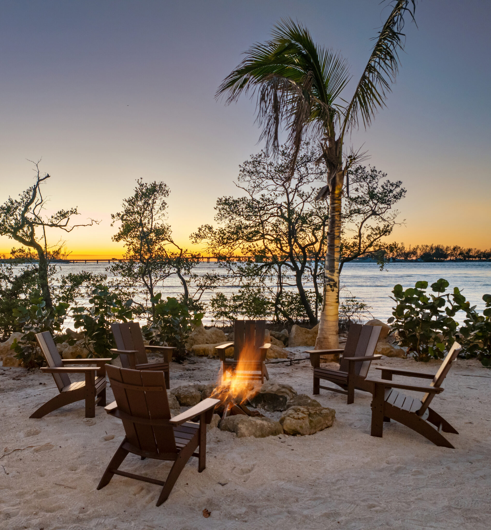 Fire pit and chairs on the beach at sunset