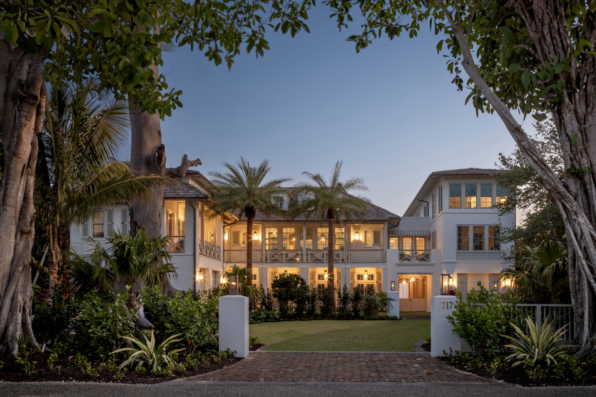 Dusk exterior of the North Shore Residence beneath mature palms, a beachfront custom home on Anna Maria Island