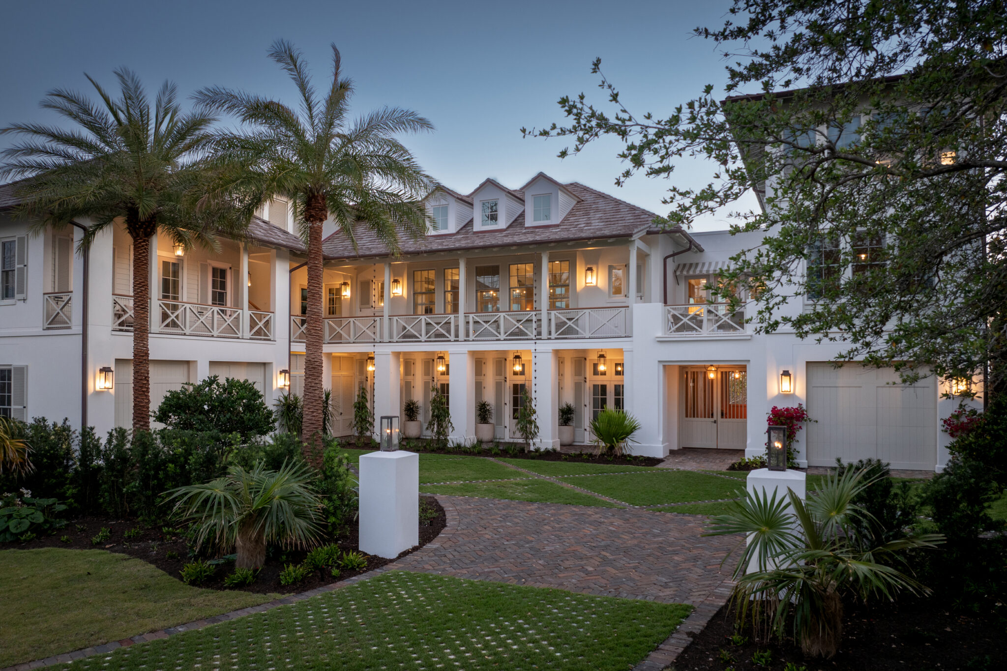Front of the North Shore Residence at twilight, framed by palms