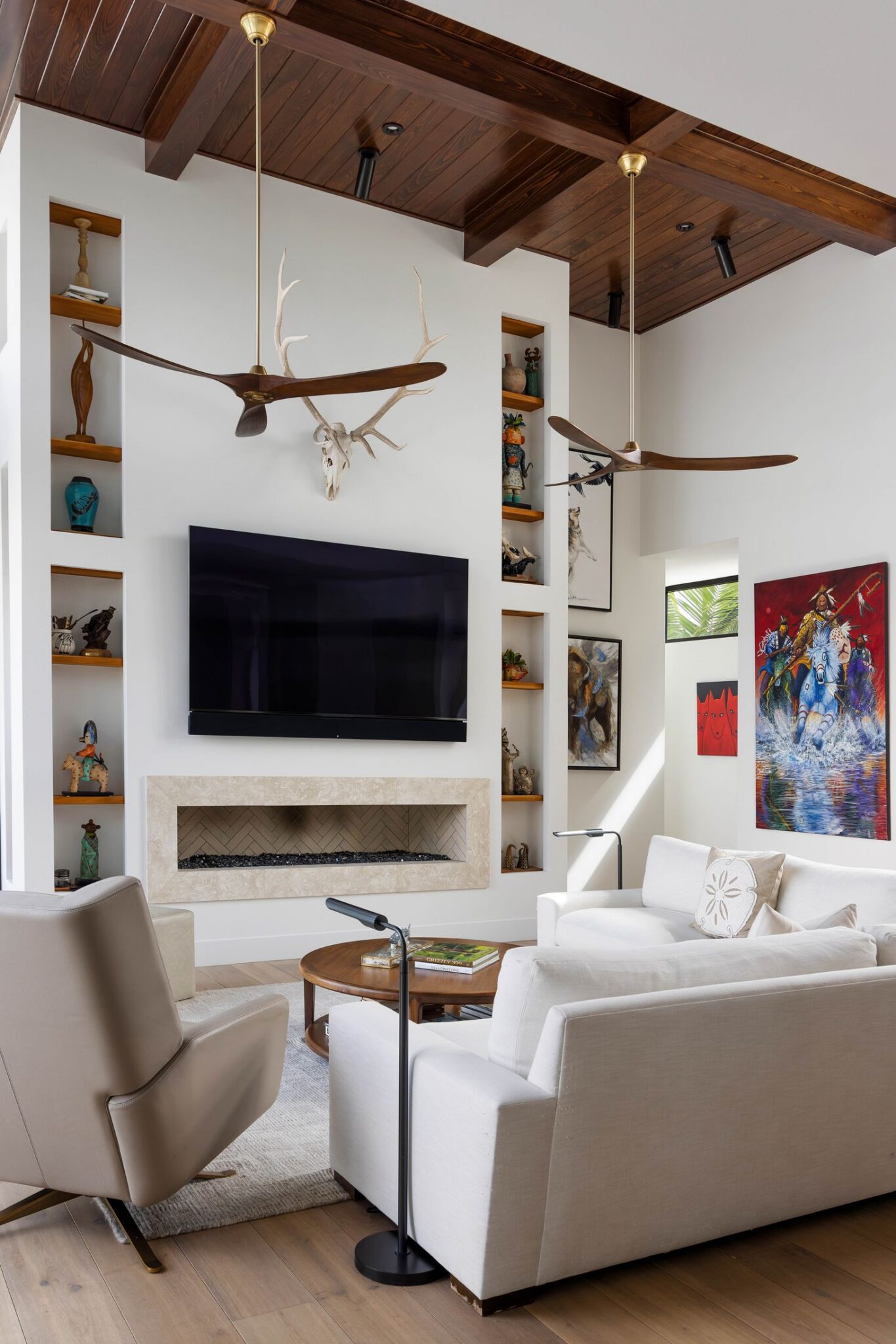 Two-story fireplace wall with built-in display niches beneath a wood-beamed ceiling