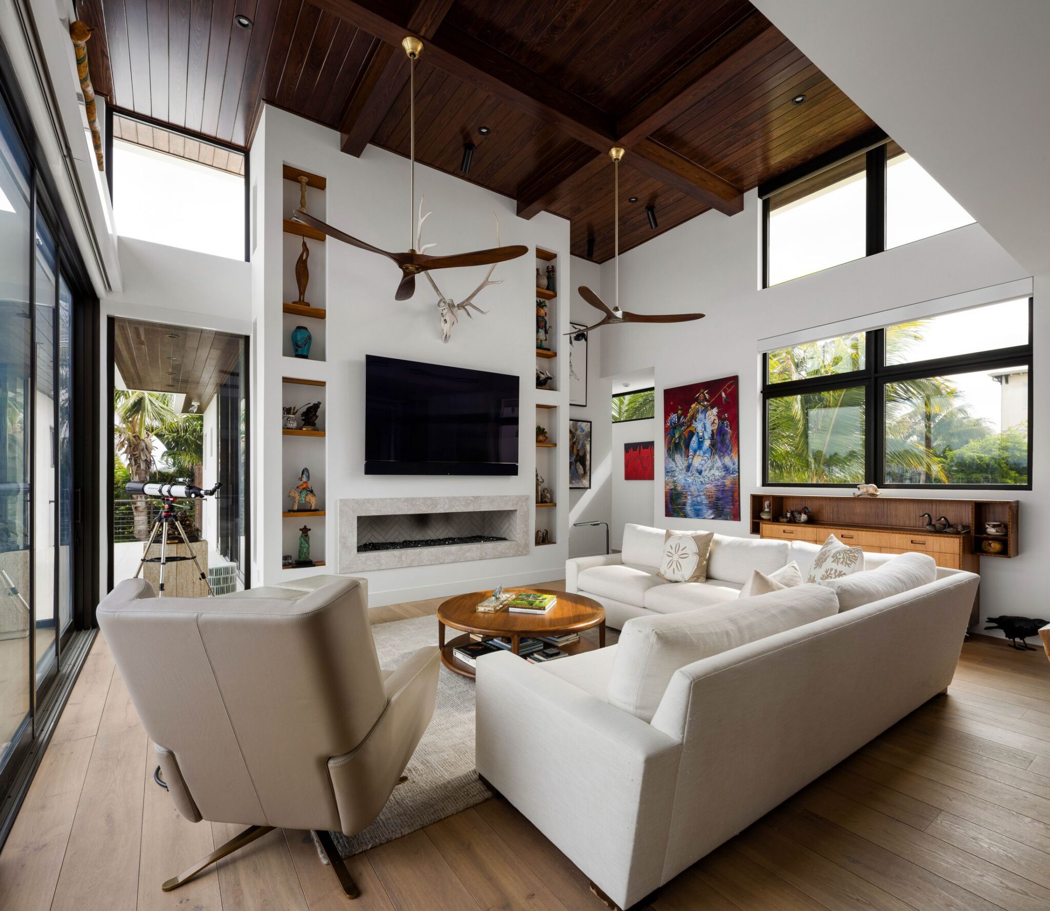 Living room with a wood-beamed ceiling, linear fireplace and glass walls to the water