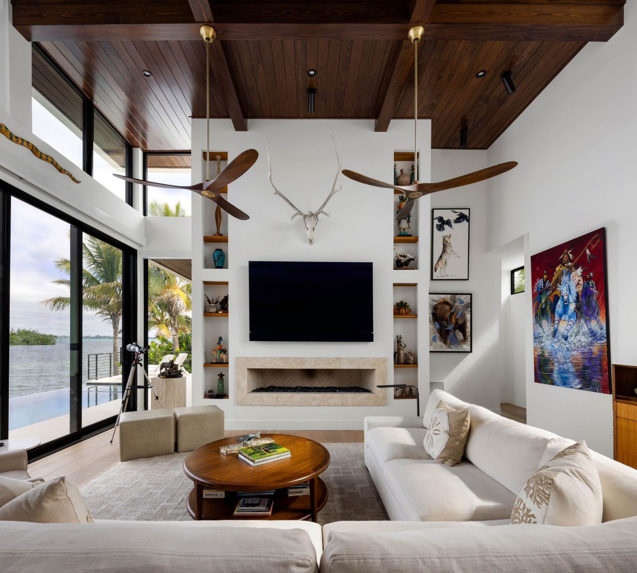Great room with a two-story wood ceiling, fireplace wall and sliding glass doors to the pool