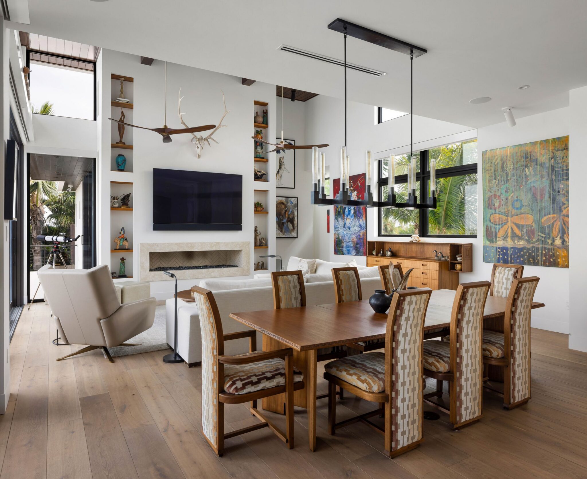 Dining area beside the great room with a linear chandelier and walnut table