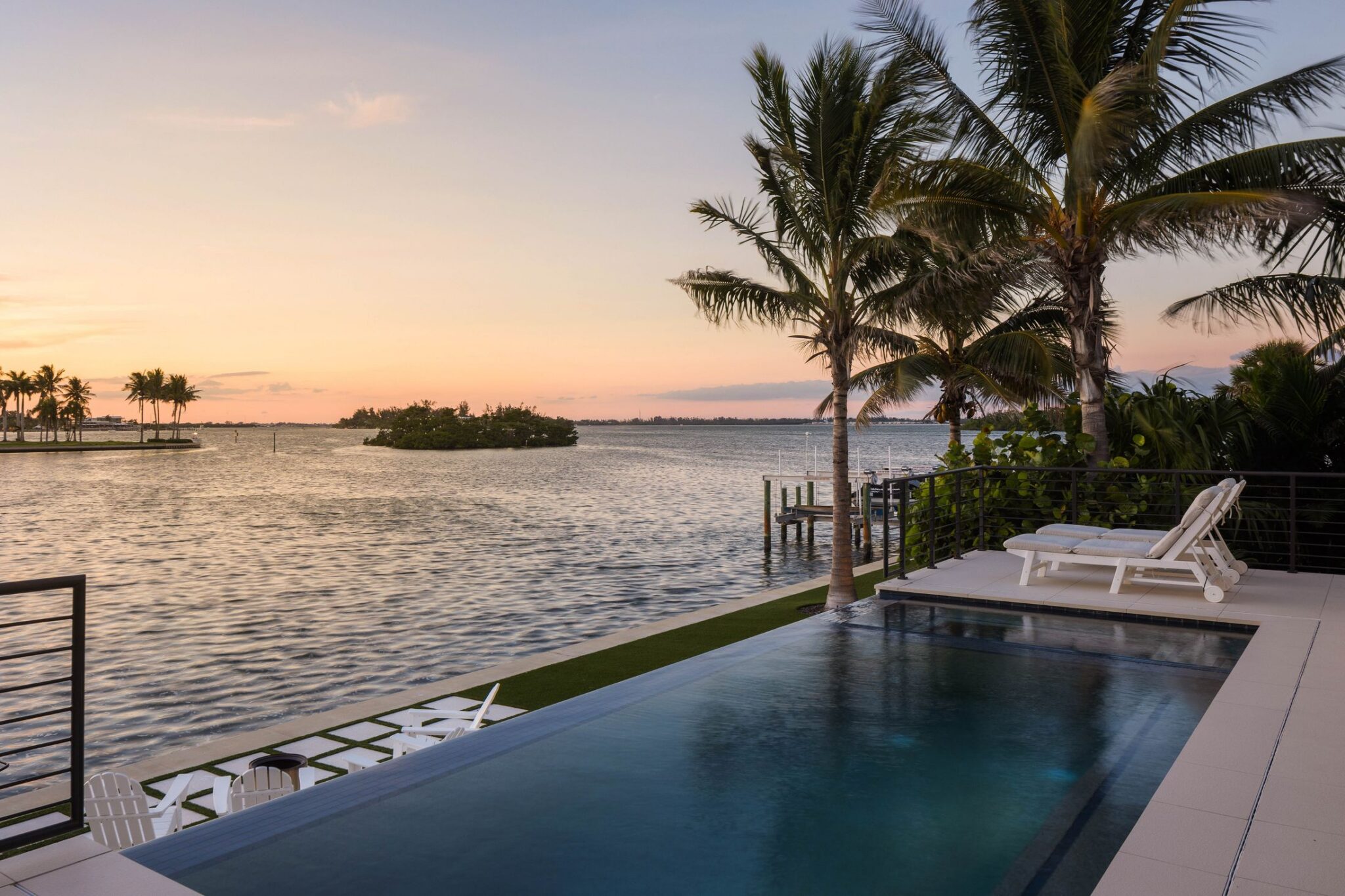 Infinity-edge pool facing the bay and mangrove islands at sunset