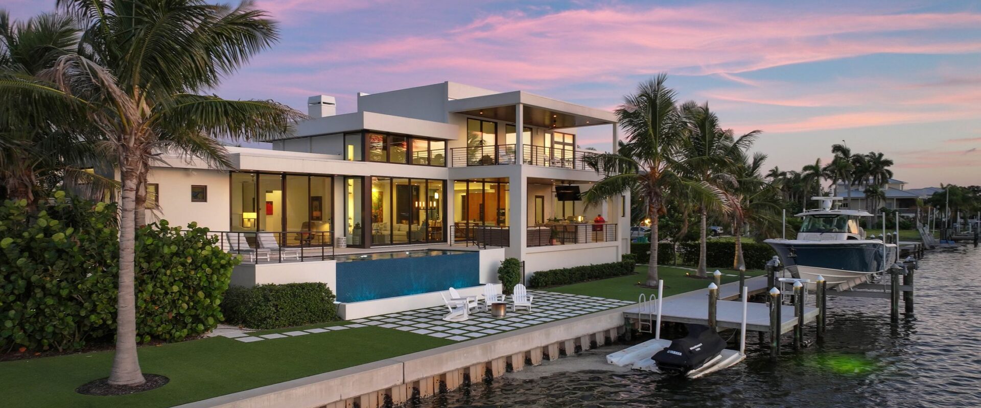 Bayview Residence at twilight from the seawall, with the infinity-edge pool and dock