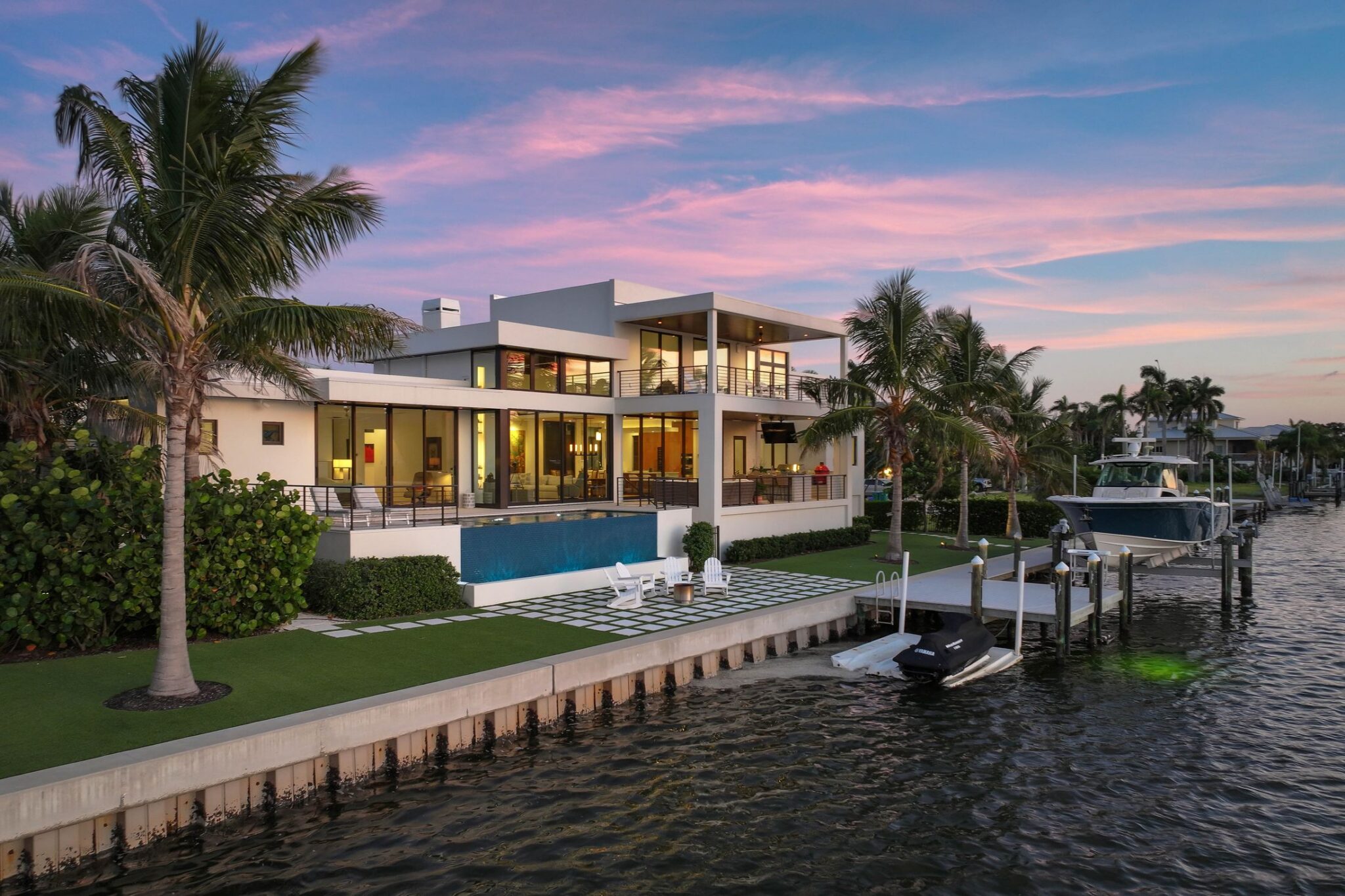 Bayview Residence at twilight from the seawall, with the infinity-edge pool and dock