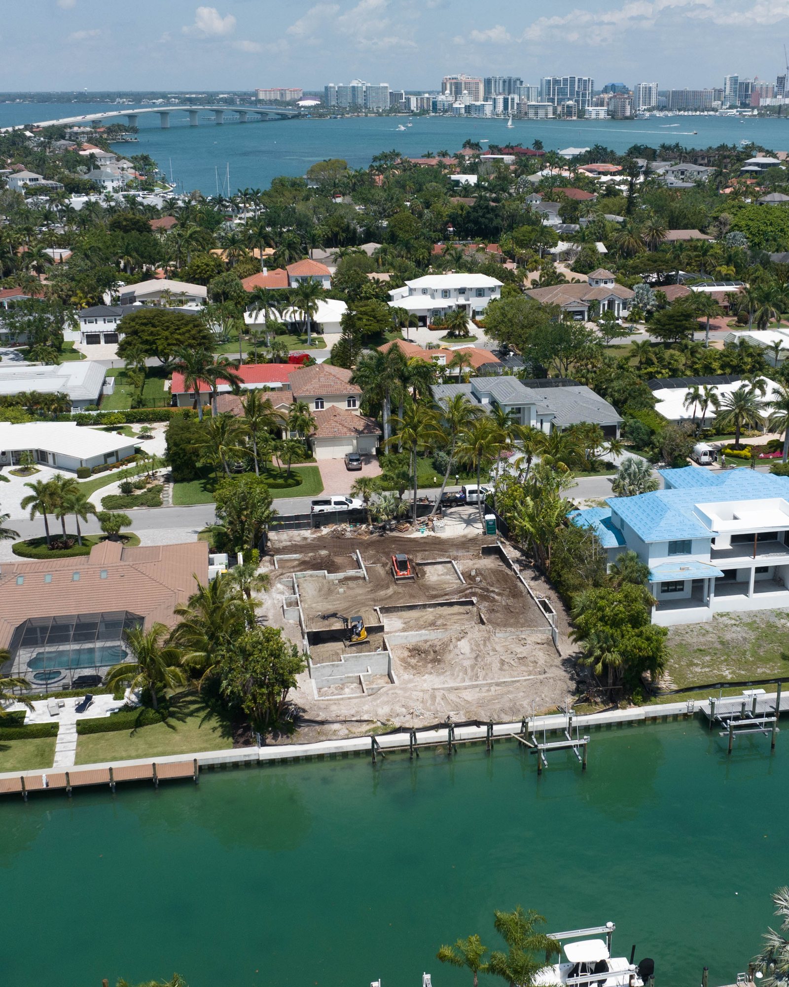 Aerial view of the foundation walls on the canal-front lot, with downtown Sarasota beyond