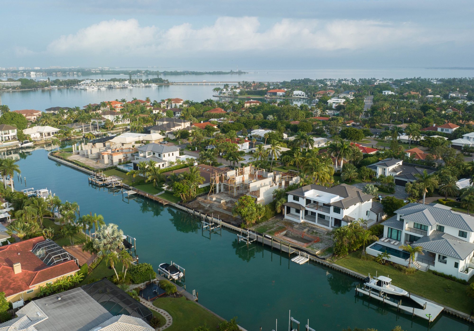 Wide aerial view of the home under construction on a Bird Key canal