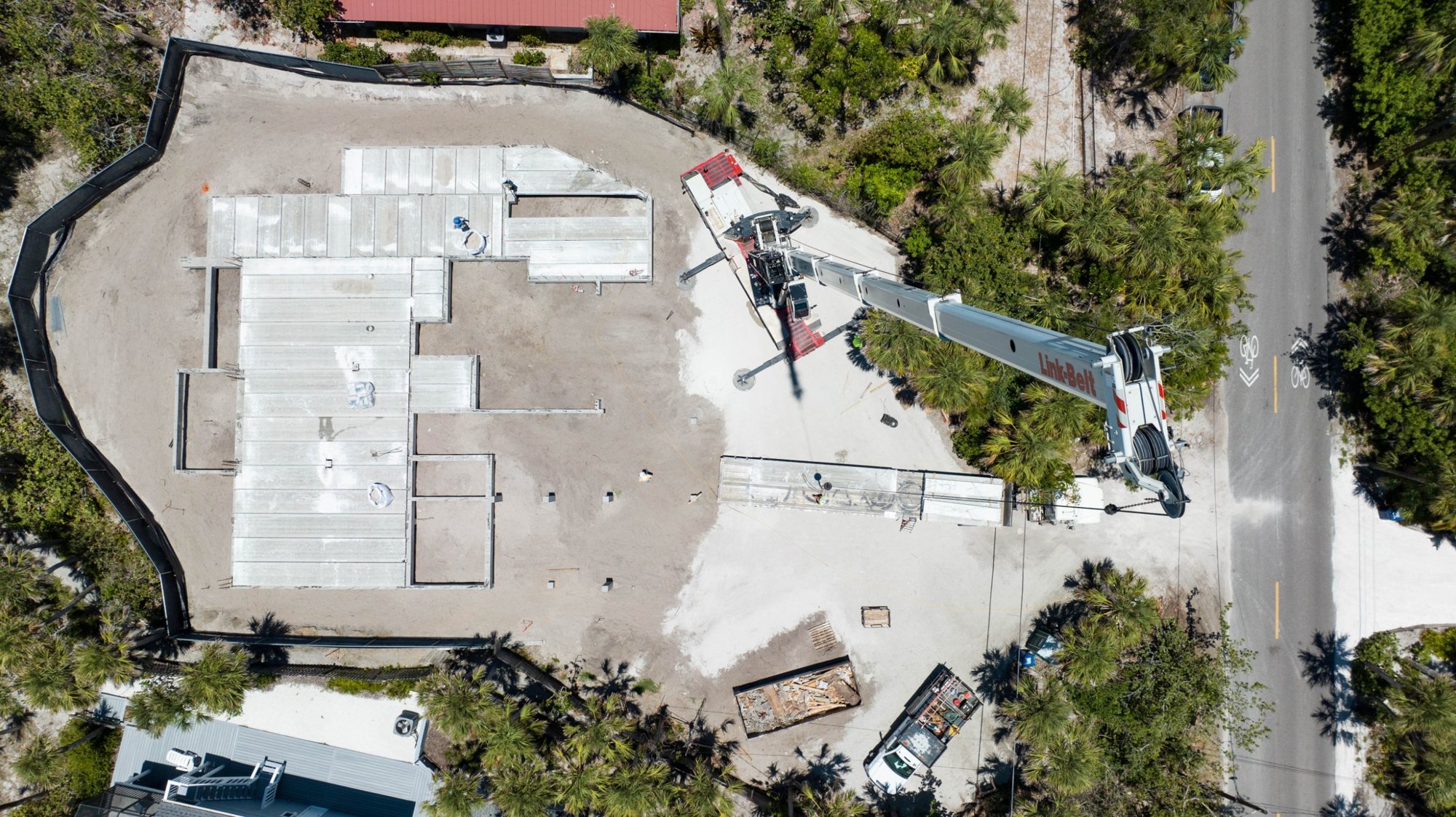 Overhead view of a crane setting precast floor planks on the foundation