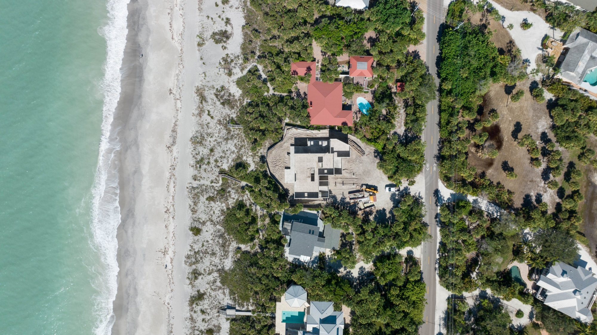 Overhead view of the masonry walls going up between the road and the beach