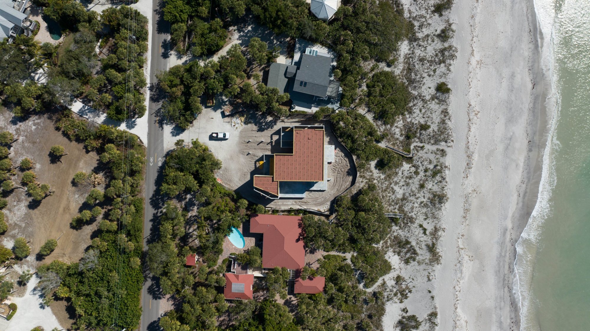 Overhead view of the sheathed roof between the road and the beach