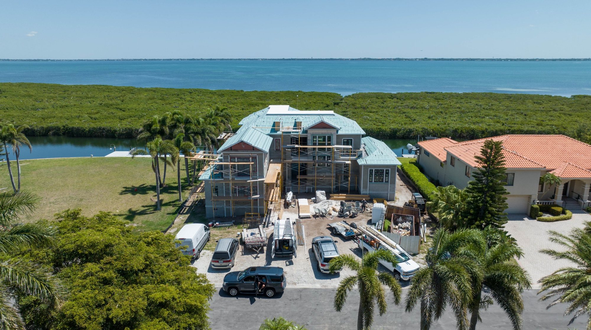 Aerial view of Longboat Key Seaside Residence under construction from the street, with the bay beyond