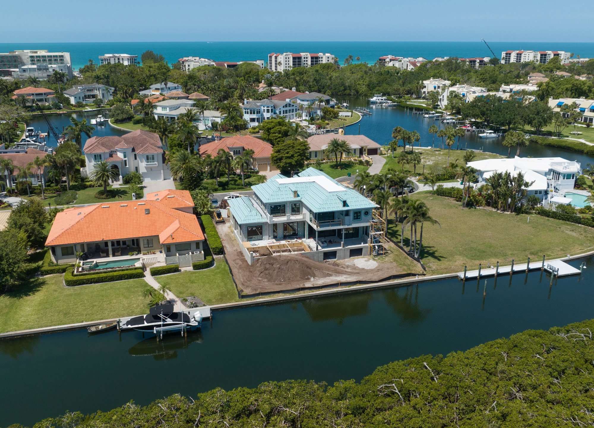 Aerial view of Longboat Key Seaside Residence under construction from the canal, with the Gulf beyond